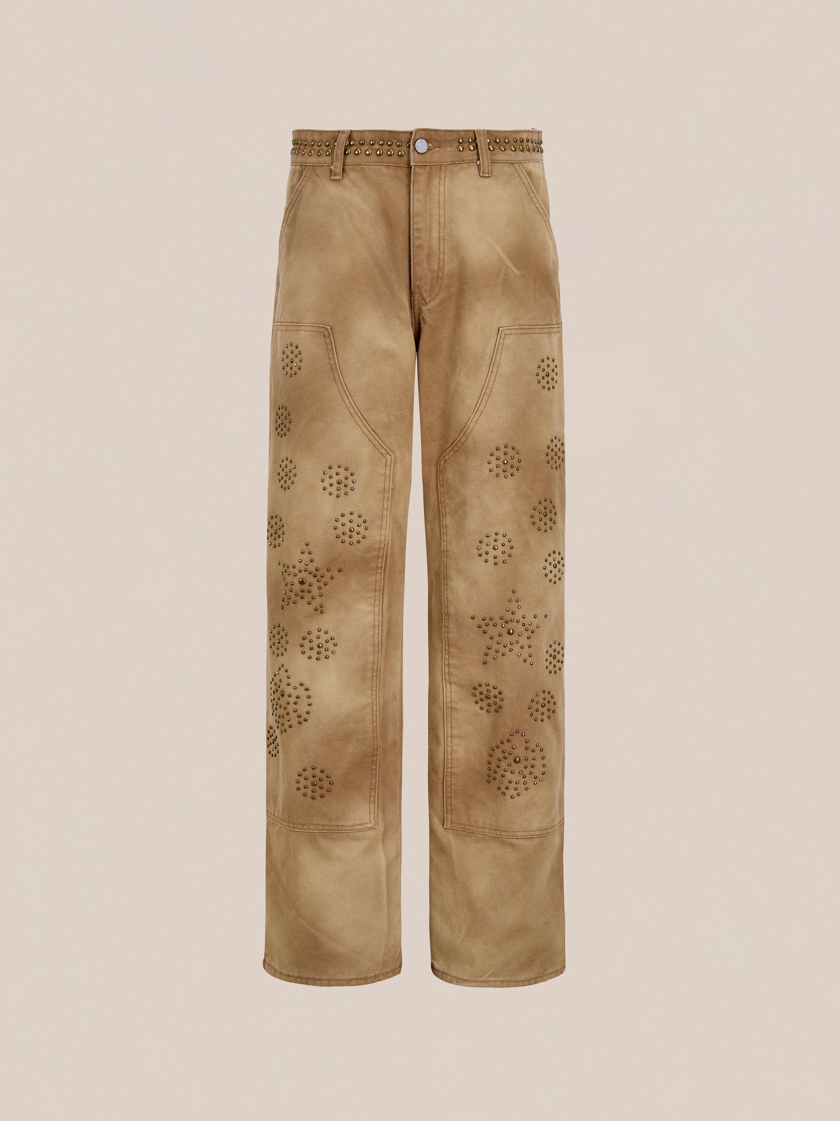 FOUND Canvas Studded Work Pants: unisex wide-leg tan utility pants with decorative circular patterns on the front and metal eyelet details at the waistband, shown against a plain background.