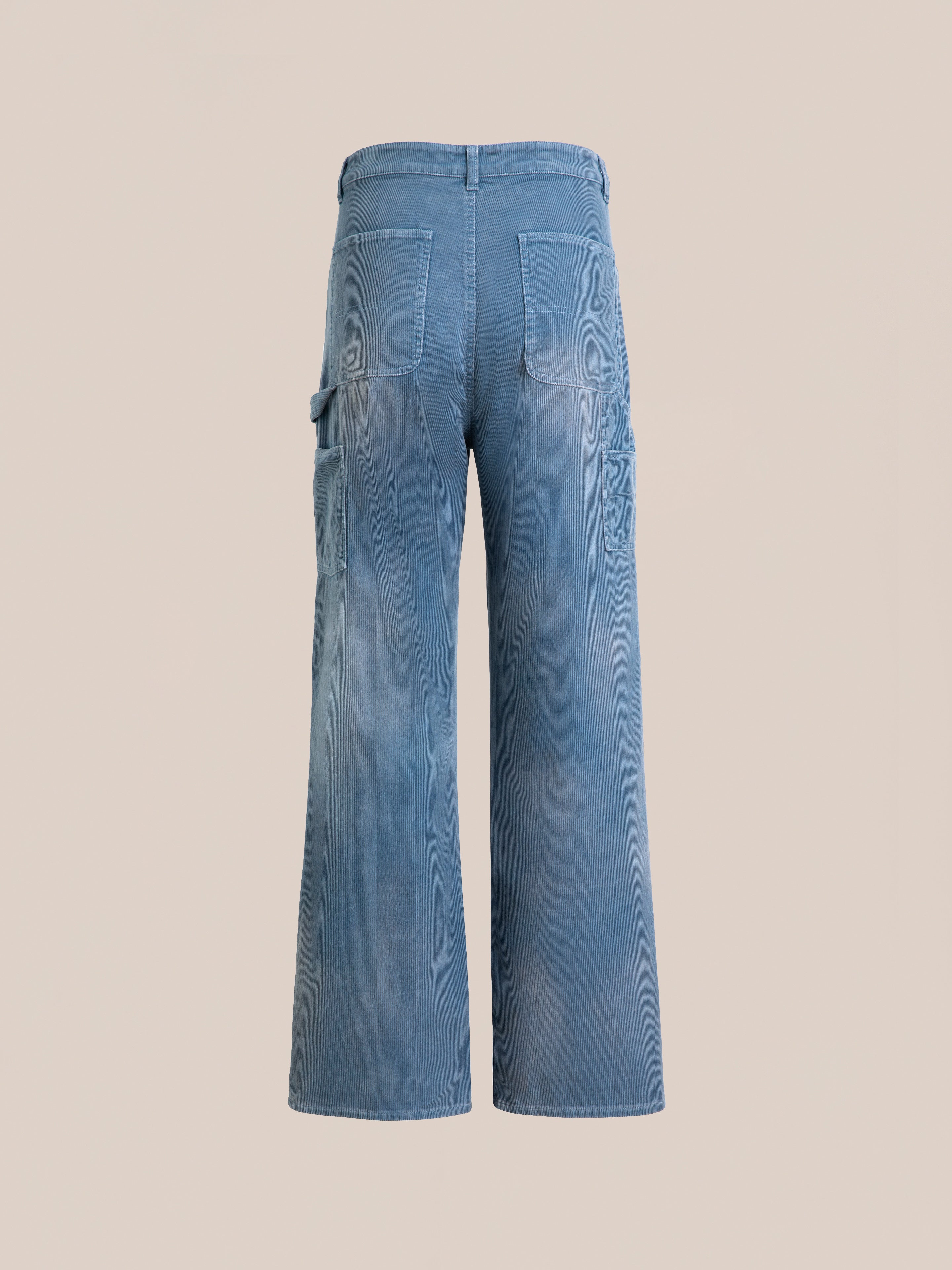 Back view of FOUND Corduroy Flare Work Pants in light blue, featuring a relaxed fit, wide legs, two back pockets, and side cargo pockets, channeling vintage style, shown on a plain beige background.