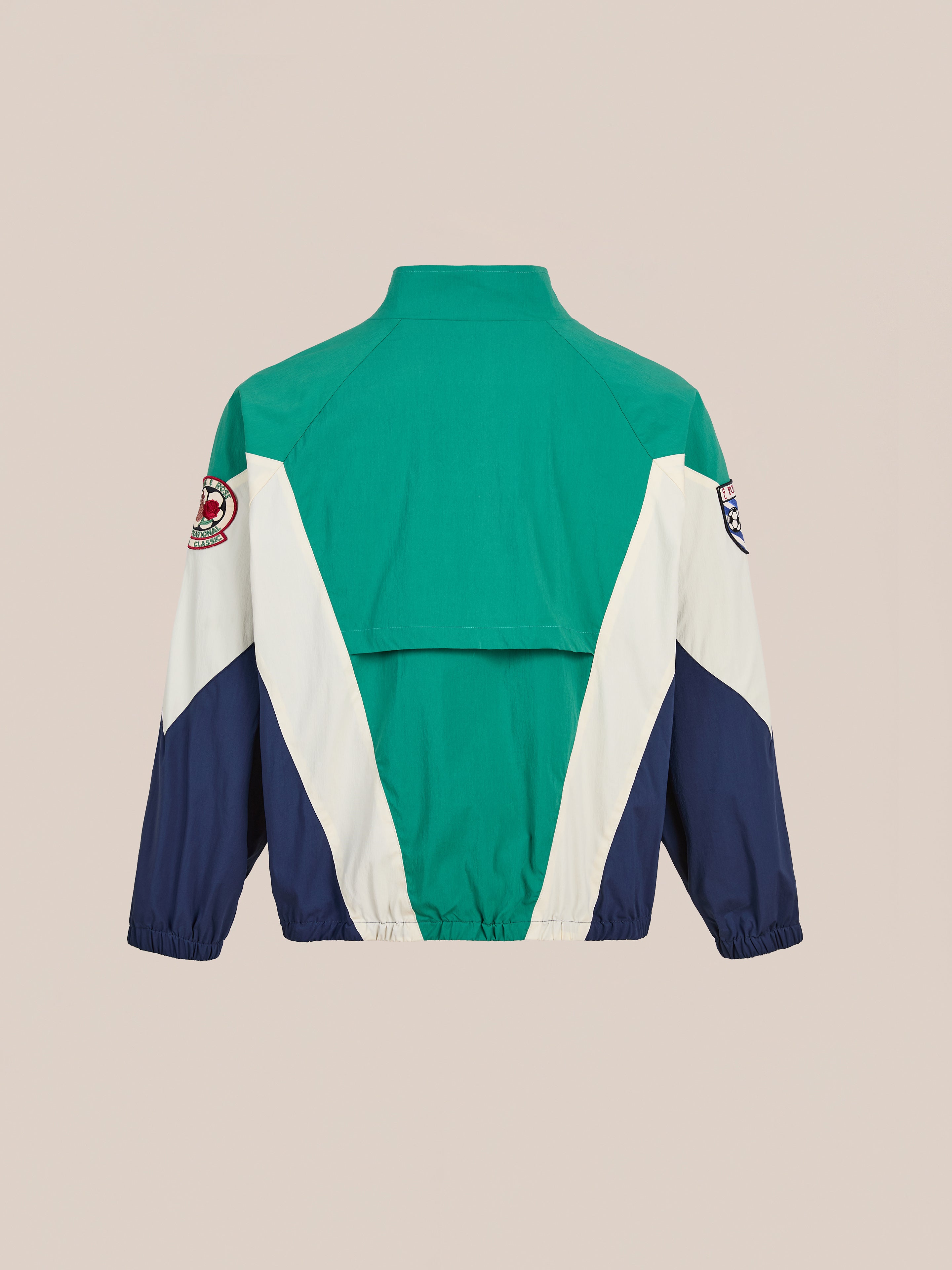 The FOUND Crestline Sport Zip Jacket is a vintage sportswear-inspired windbreaker with green, white, and navy colorblock panels, two sleeve patches, and an elastic hem for a classic back view.
