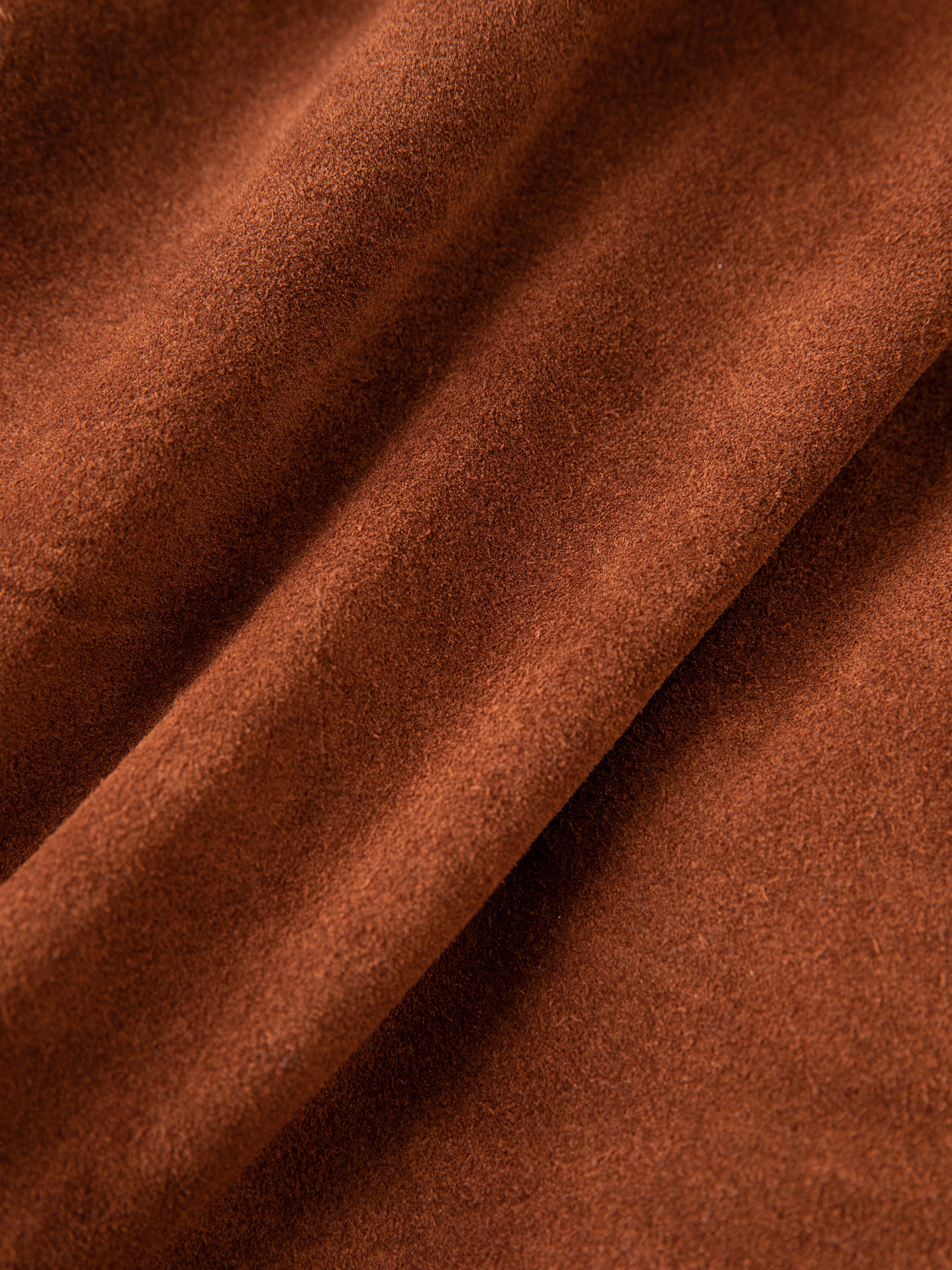 A close-up of natural hand-distressed leather from the FOUND Double Breasted Suede Leather Jacket reveals its rustic charm with visible texture and gentle folds.