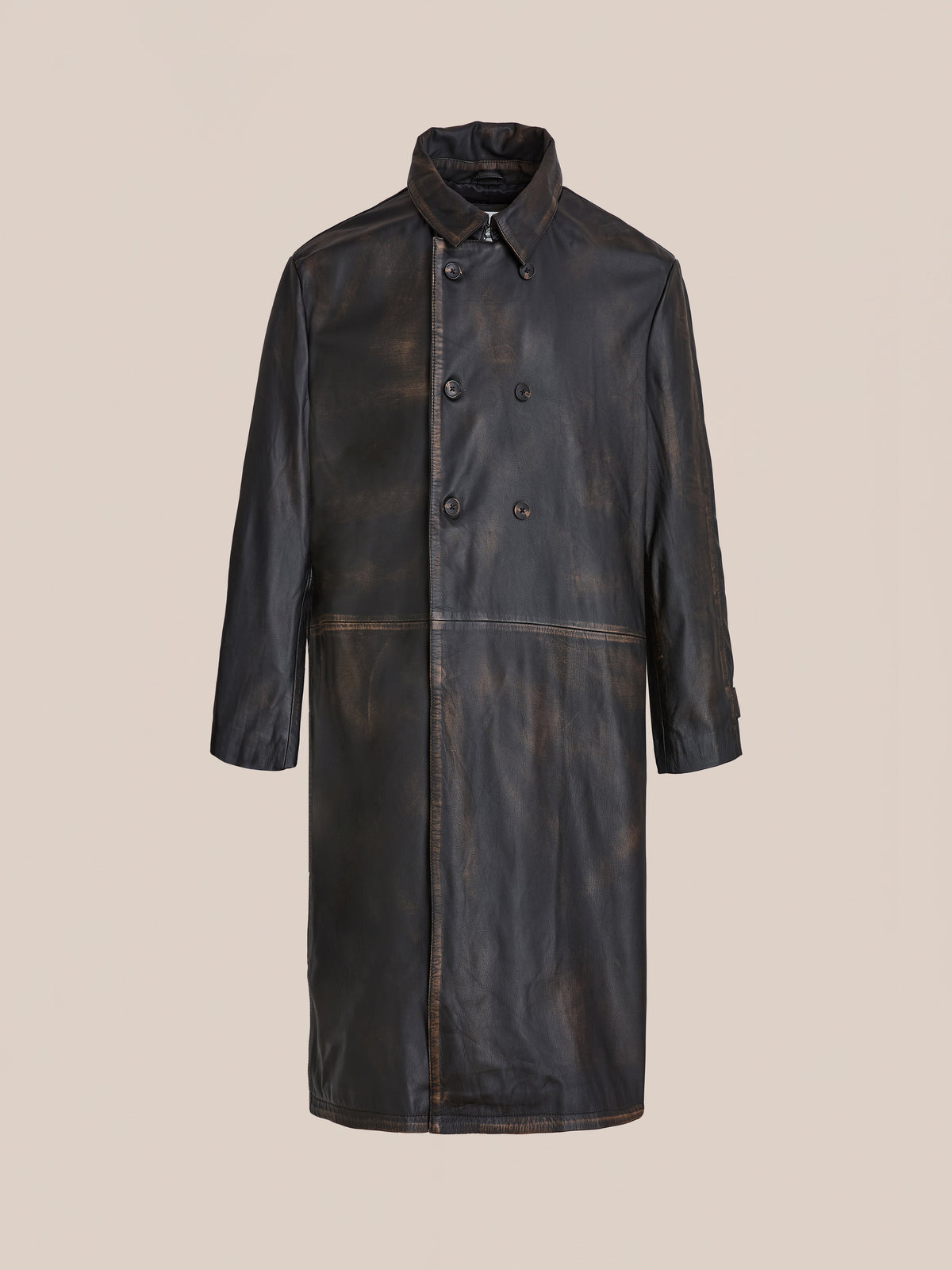 The FOUND Distressed Leather Trench Coat is a long, double-breasted black coat with a collar, button closure, and slightly distressed genuine leather finish, shown against a plain beige background.