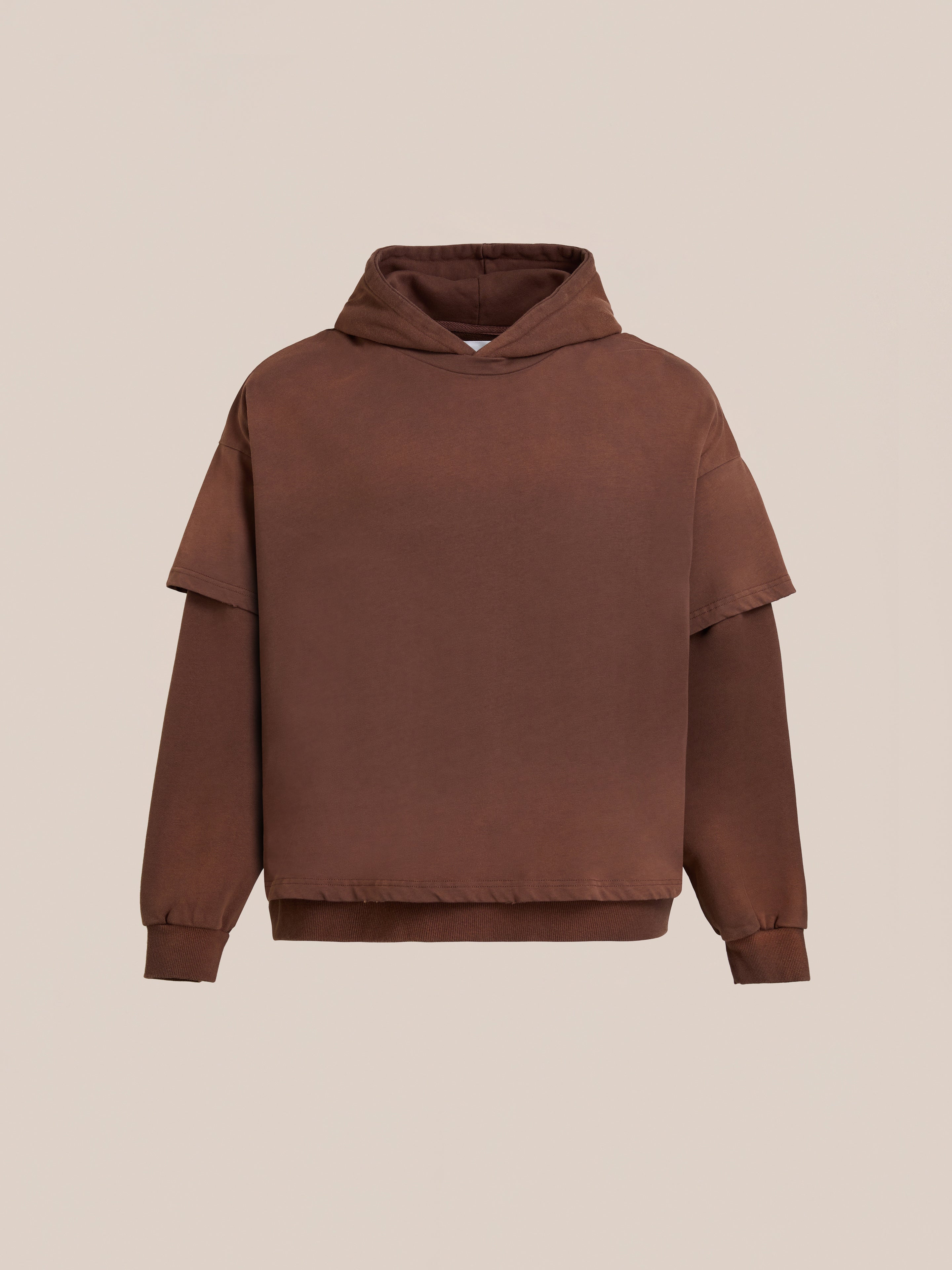 The Found Double Layer Hoodie is crafted from soft French terry cotton with a double-layered shoulder design, long sleeves, and ribbed cuffs for a cozy vintage look, shown here against a plain beige backdrop.