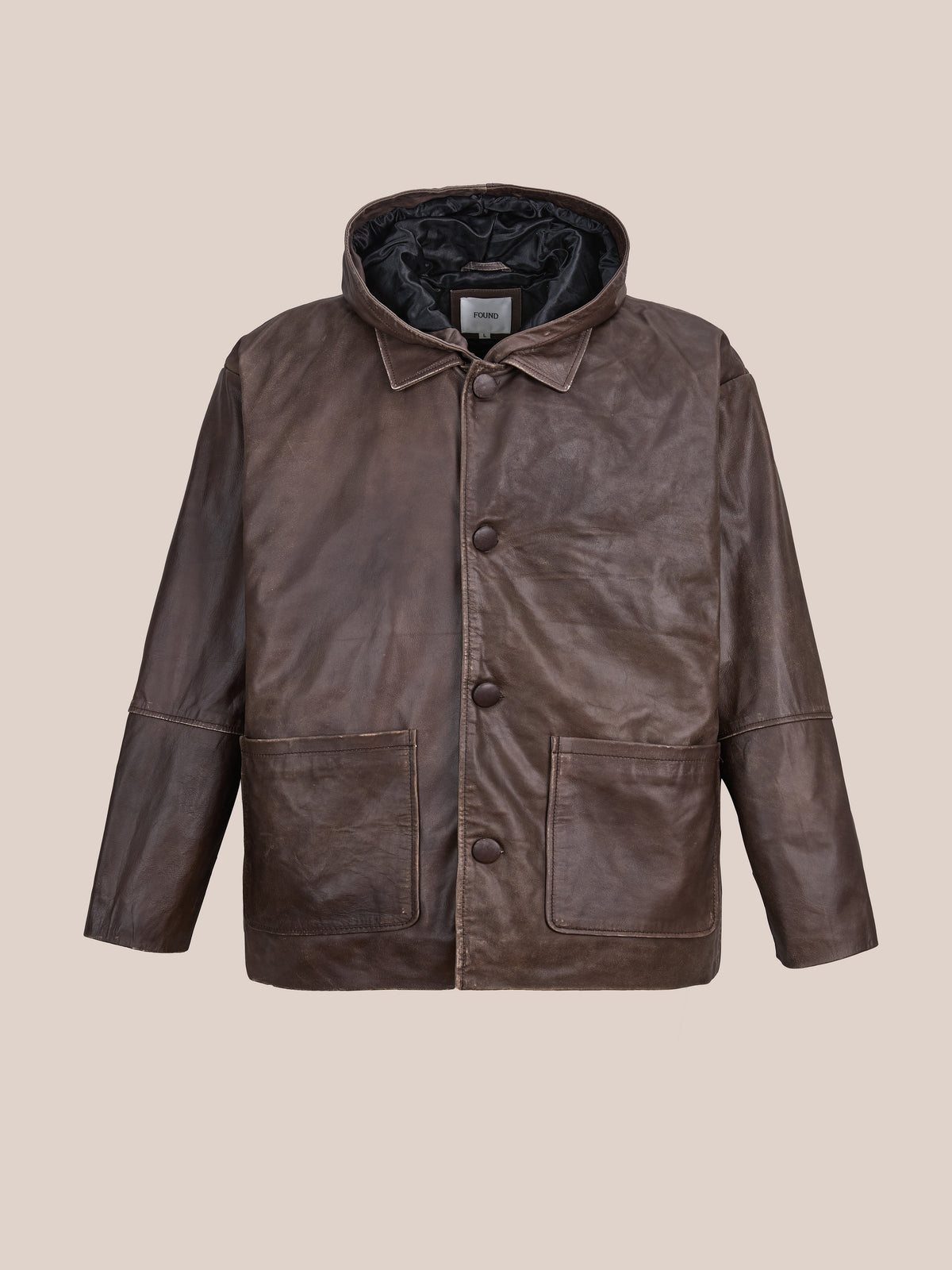 FOUND Double Layer Leather Hooded Jacket in brown leather, featuring a button closure, front patch pockets, and visible stitching. Displayed on a plain beige background, this unisex jacket combines style and versatility for any wardrobe.