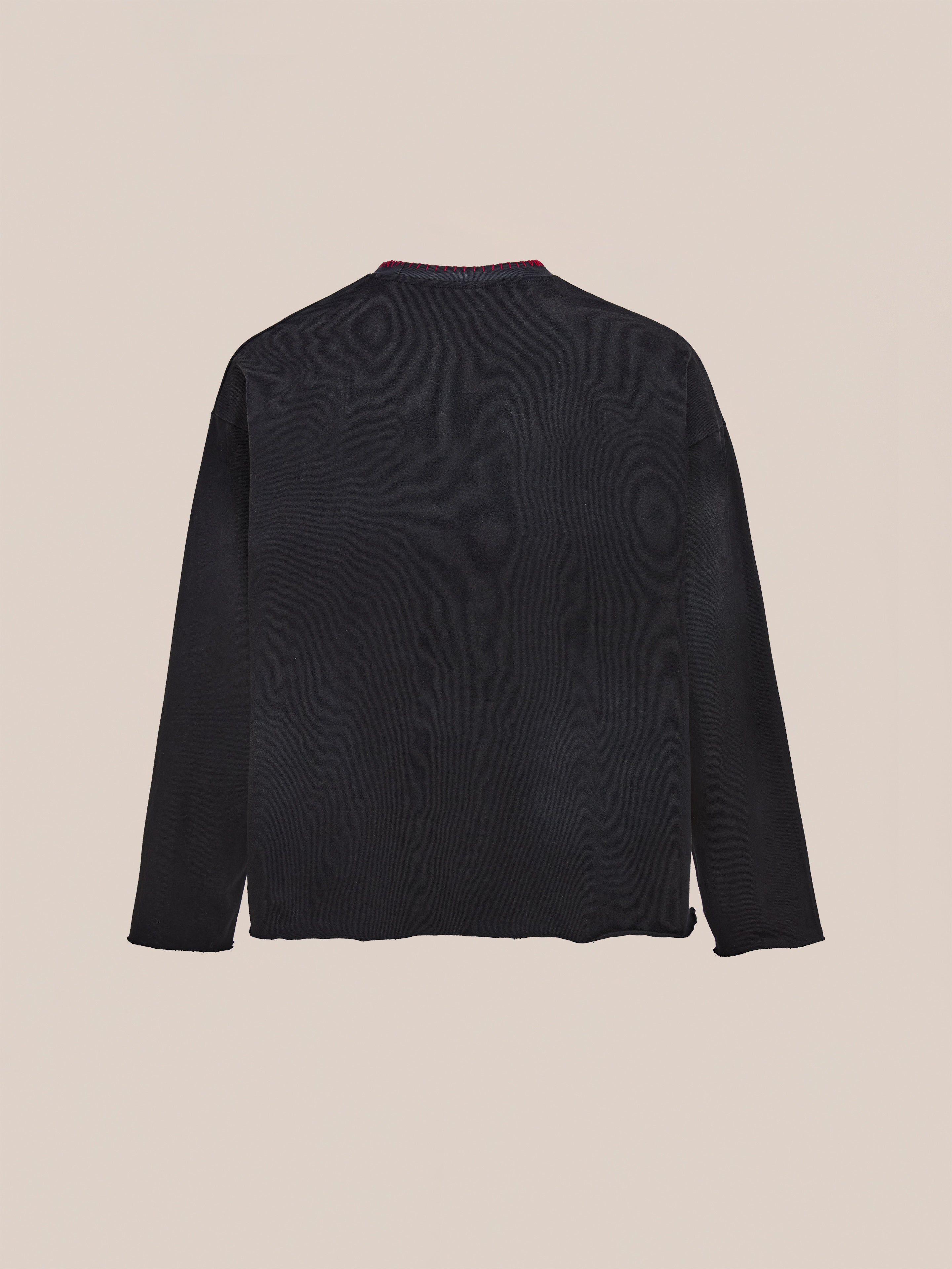 The FOUND Embroidered Patches LS Tee in vintage washed black is shown laid flat on a light beige background, displaying the back view.