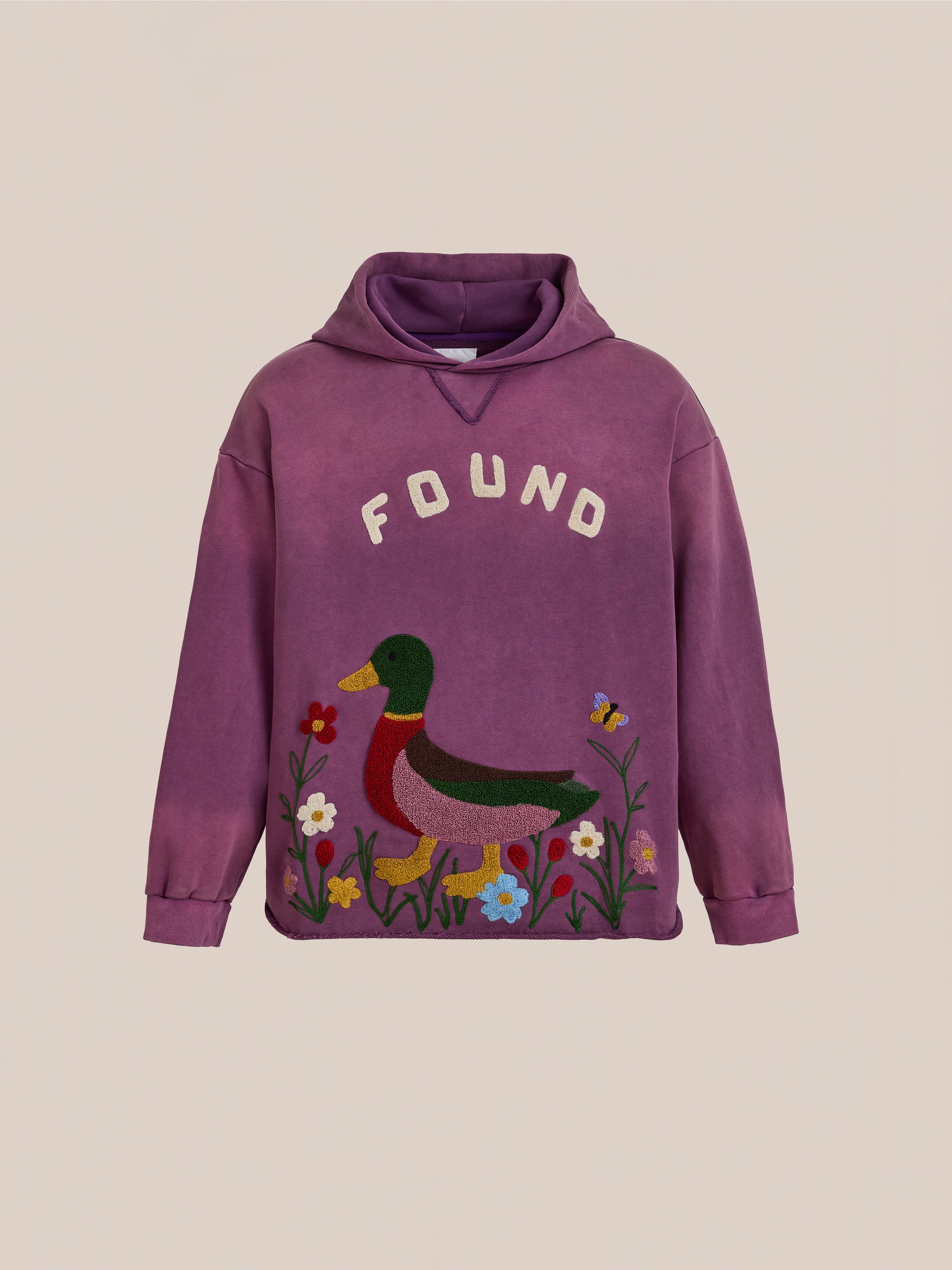 The FOUND Embroidered Wildlife Hoodie in purple features a duck among colorful flowers and plants with "FOUND" above, blending playful wildlife design and cozy retro French-terry charm.