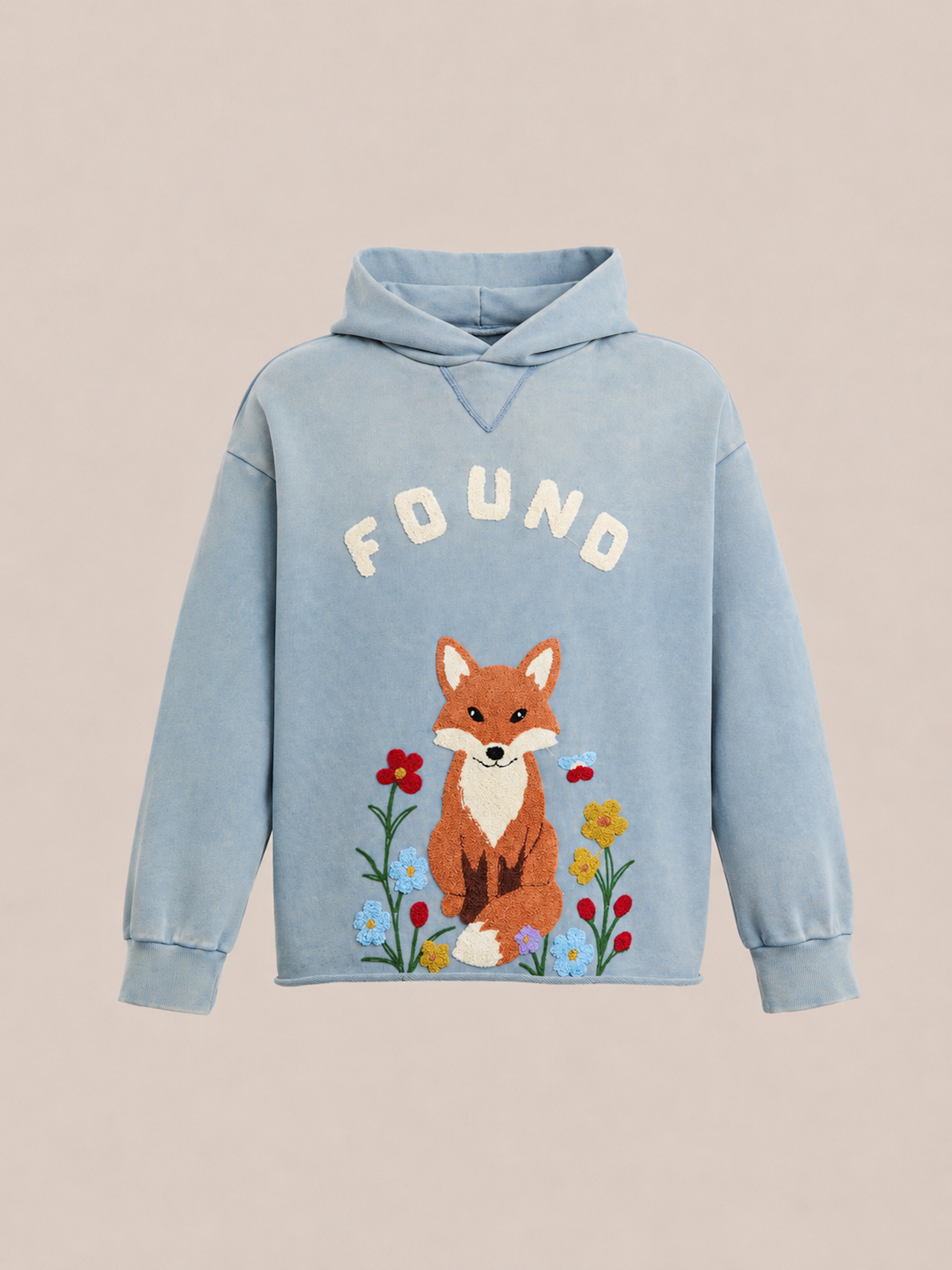 The Embroidered Wildlife Hoodie by FOUND features a light blue vintage French-terry fabric for a cozy, nostalgic feel, with the brand name “FOUND” above an embroidered fox nestled among colorful flowers on the front.