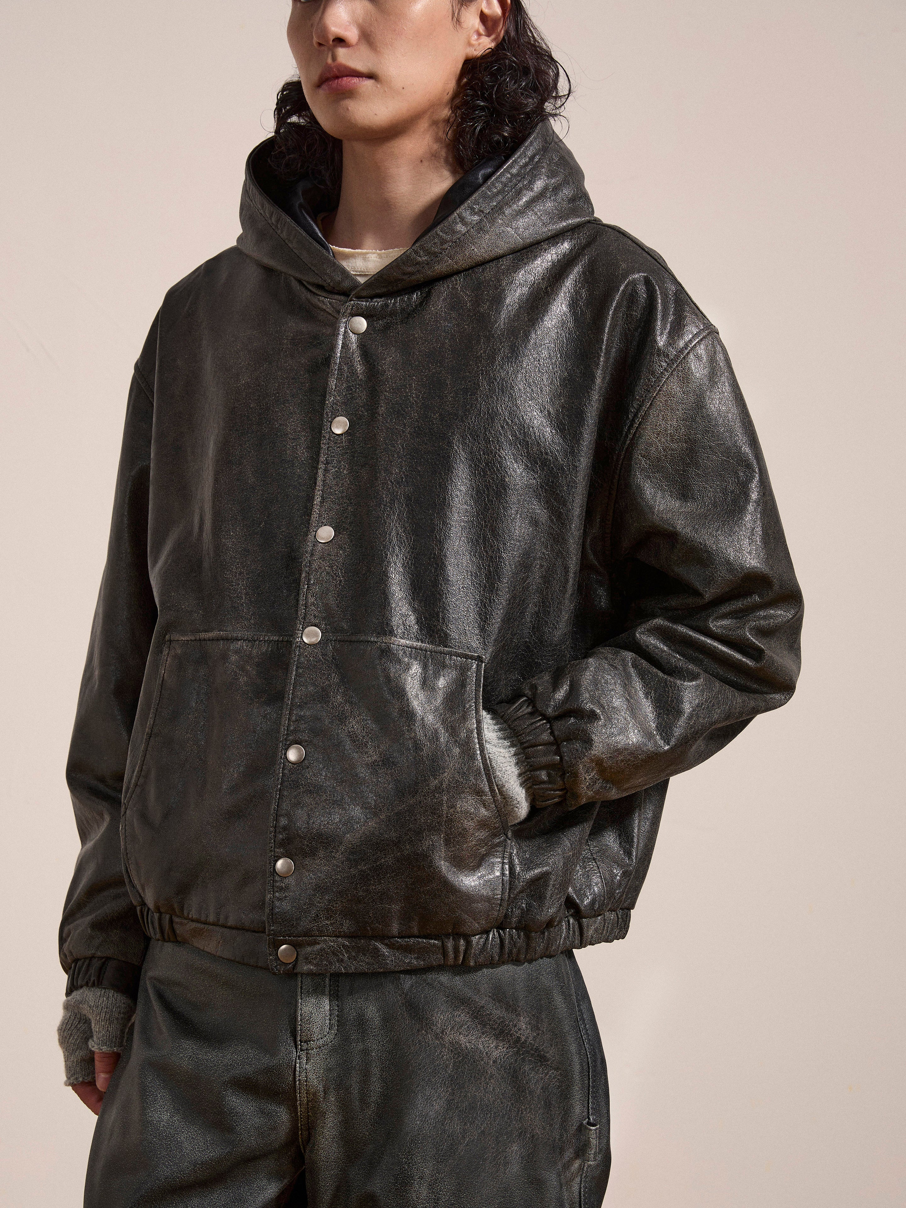 Individual adorned in Found's Distressed Genuine Leather Hoodie featuring snap buttons, along with matching leather pants crafted from ethically sourced materials, posed against a light backdrop.