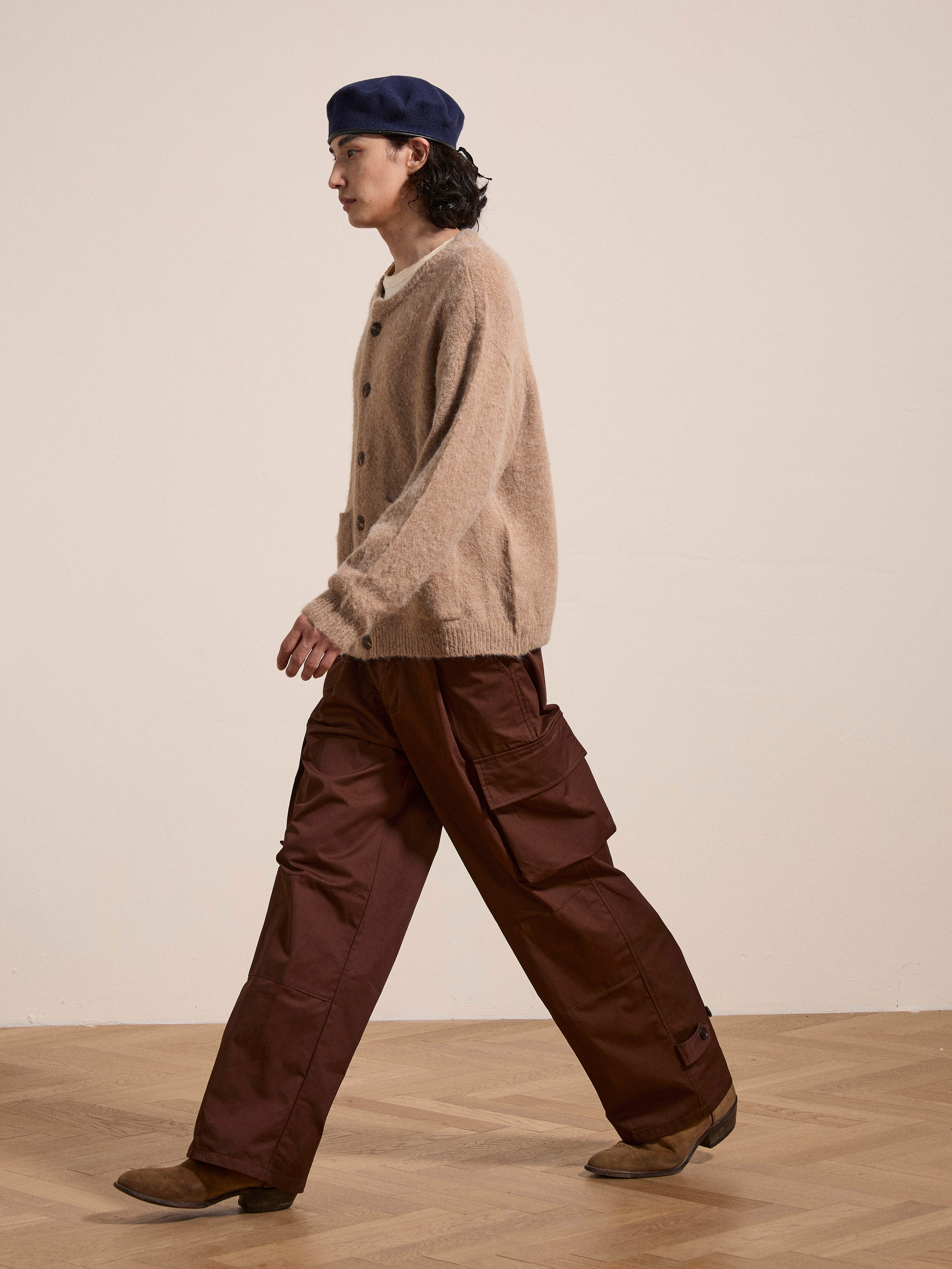 Person walking indoors wearing a blue beret, an oversized Mohair Cardigan by FOUND with tortoise buttons, brown cargo pants, and tan shoes.