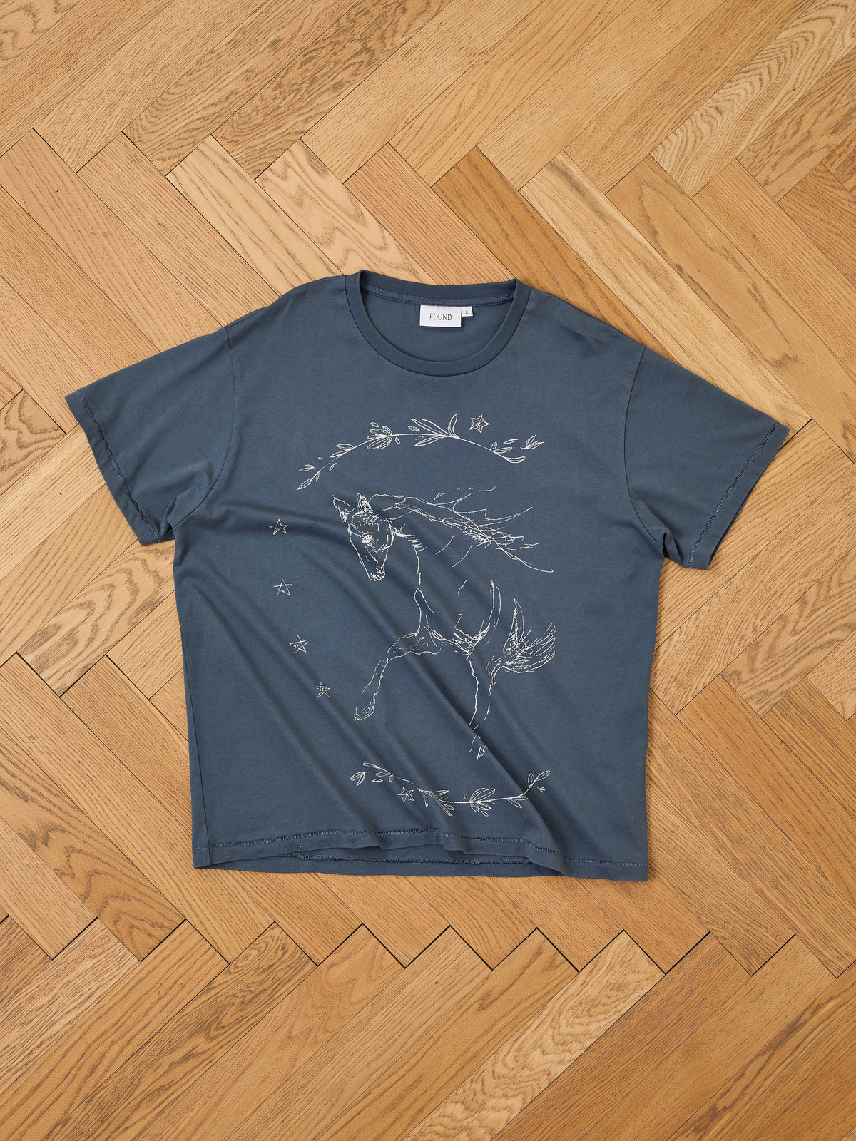 Faded Horse Trot Tee by FOUND: Dark blue unisex tee with white horse, stars, and leaves graphic. Relaxed fit.