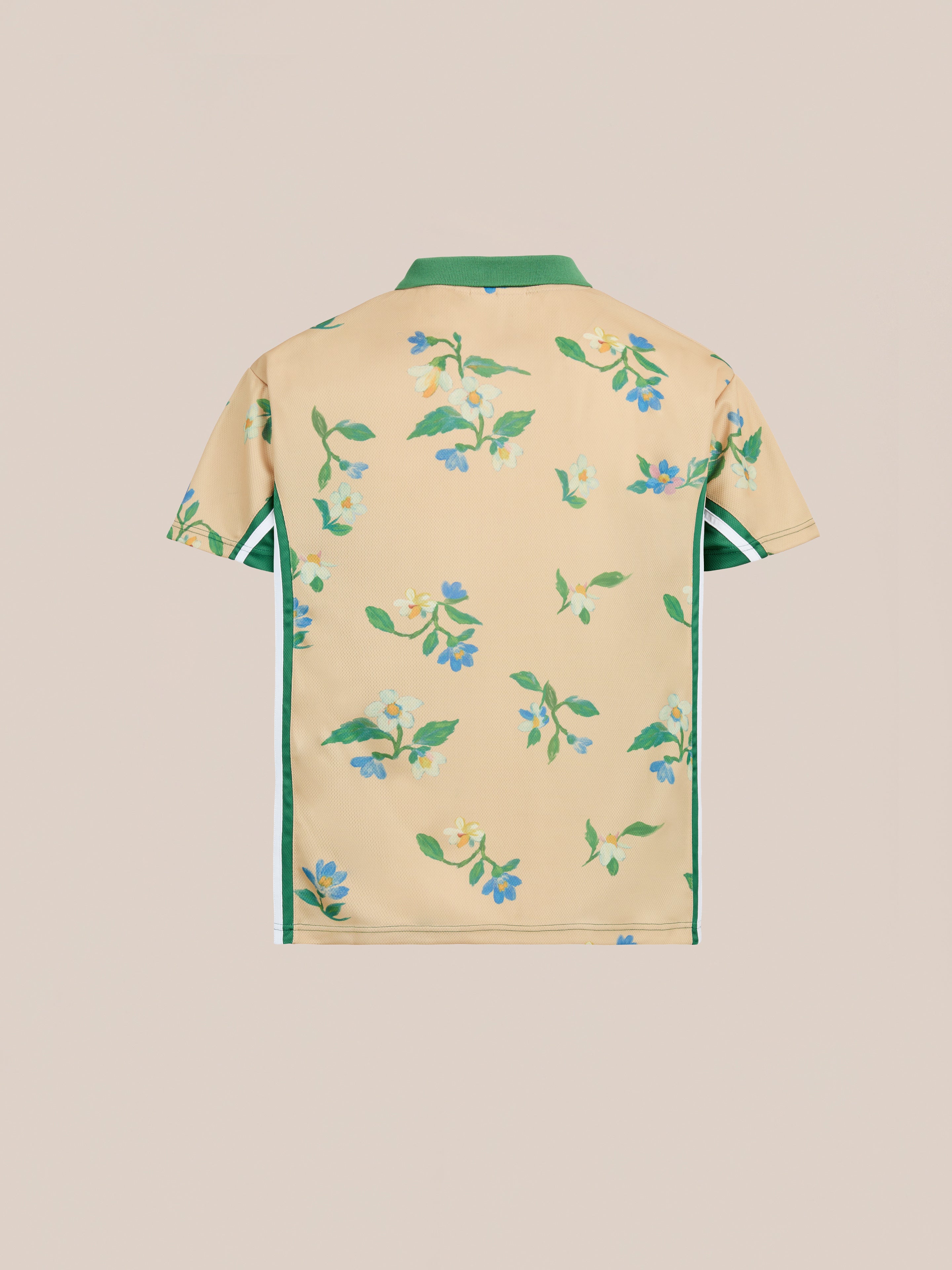 The FOUND Floral Polo Jersey is a unisex, relaxed-fit sporting polo in beige with a green collar, side stripes, and vintage flair, featuring a back print of green leaves and blue flowers.