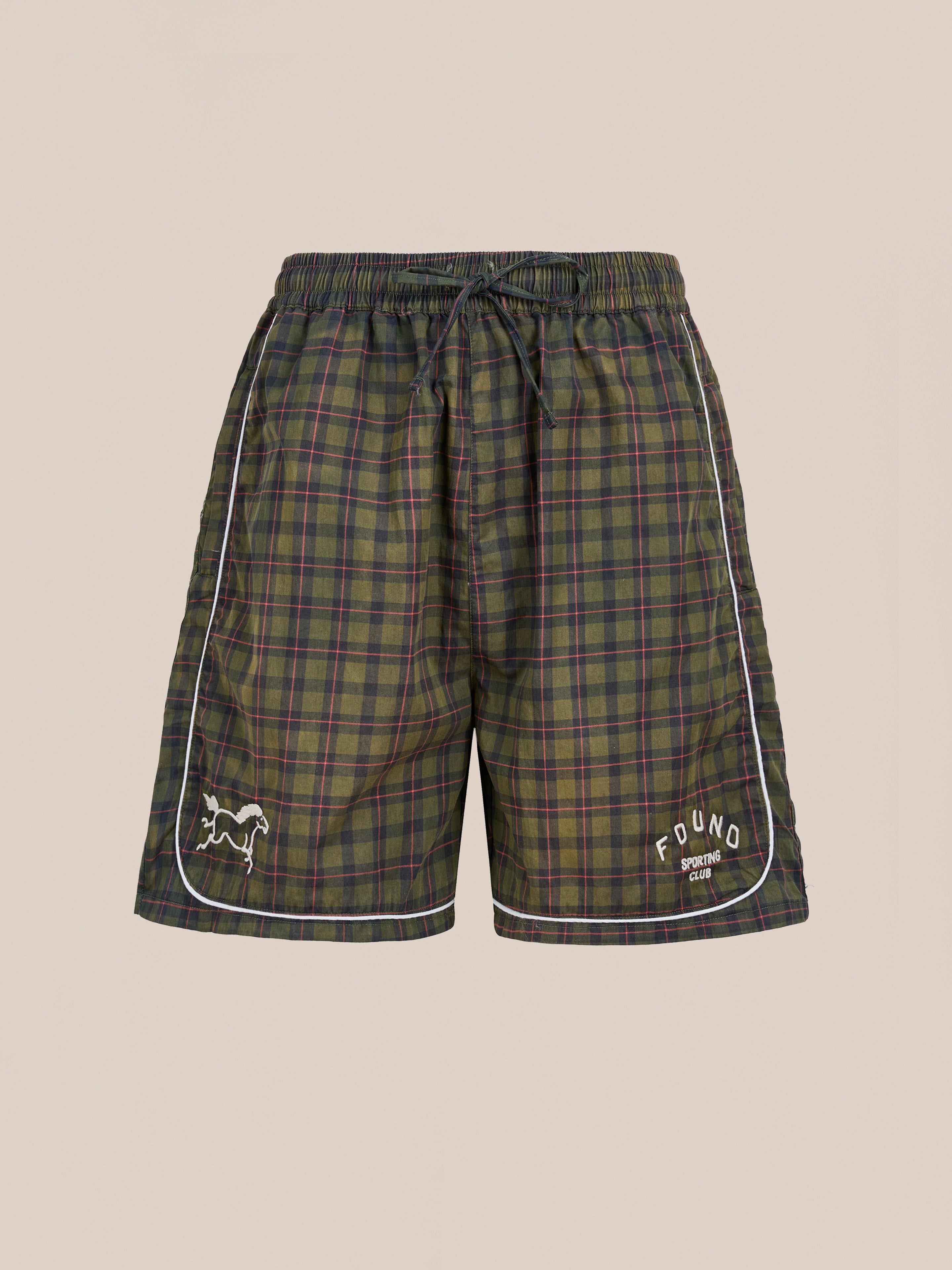 Found’s Forest Plaid Track Shorts feature a green and blue plaid design, drawstring waistband, white piping, and embroidered logos. These unisex vintage athletic shorts offer a relaxed fit for classic comfort and sporty style.