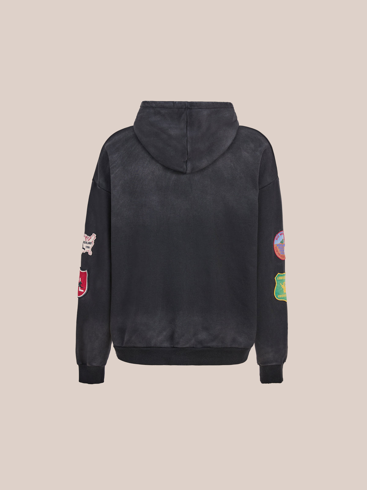 The FOUND Found Logo Patch Hoodie is pictured from the back, highlighting colorful patch detailing along the sleeves against a clean light background. This unisex relaxed-fit sweatshirt by FOUND blends everyday comfort with distinctive style, making it a standout staple in any wardrobe.