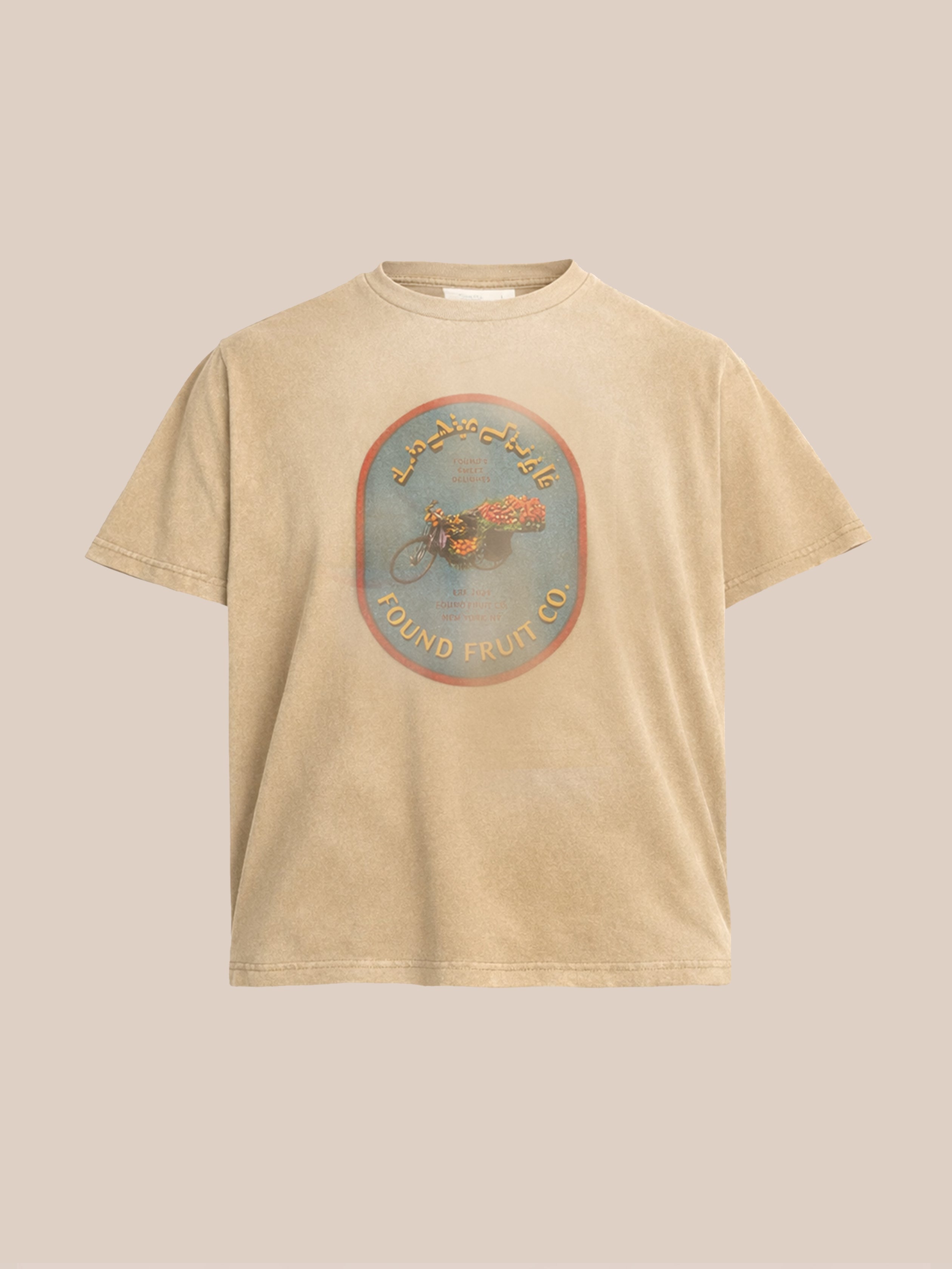 The FOUND Fruit Co Tee is a beige unisex graphic tee with a round emblem, fruit fly illustration, and "FOUND FRUIT CO." in English and Arabic. It offers a relaxed fit for everyday comfort.