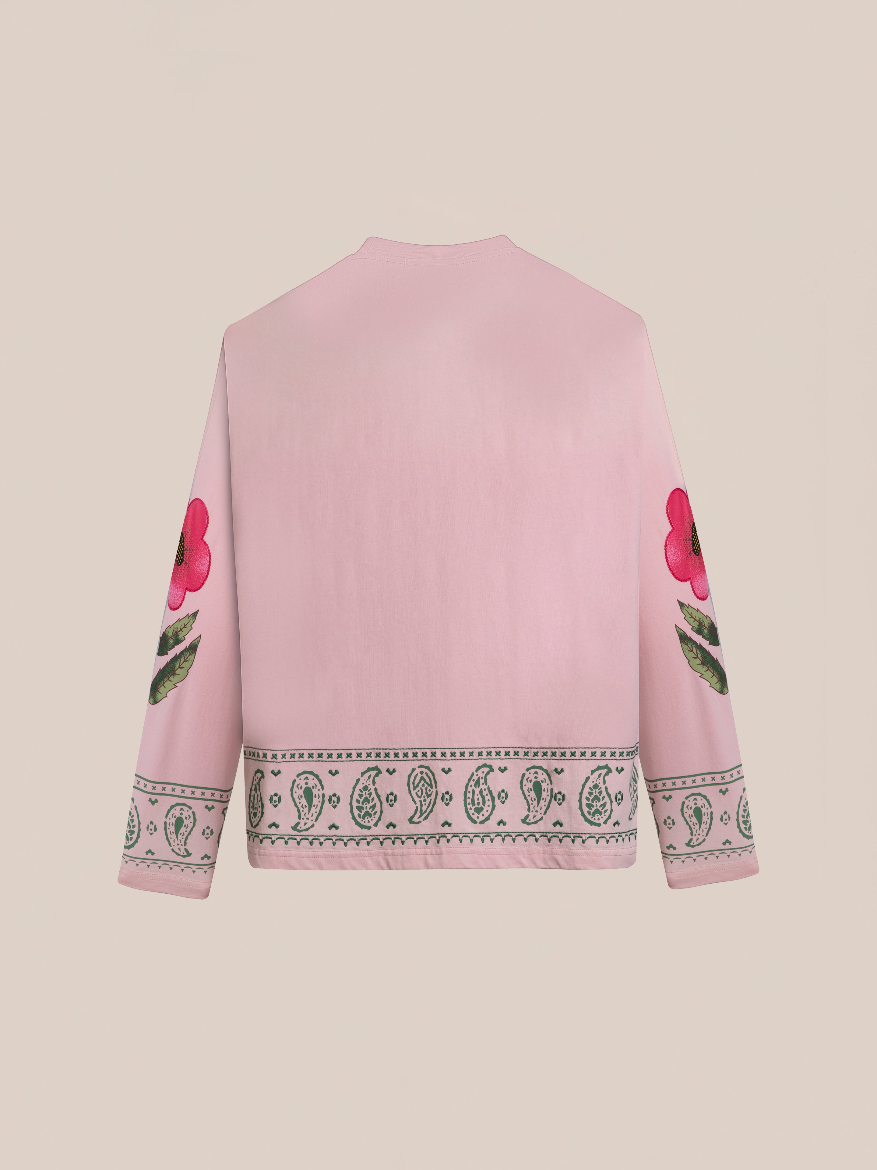 The FOUND Garden Bloom Embroidered LS Tee is a light pink unisex relaxed fit shirt with floral sleeve graphics and a decorative bottom border, shown from the back.
