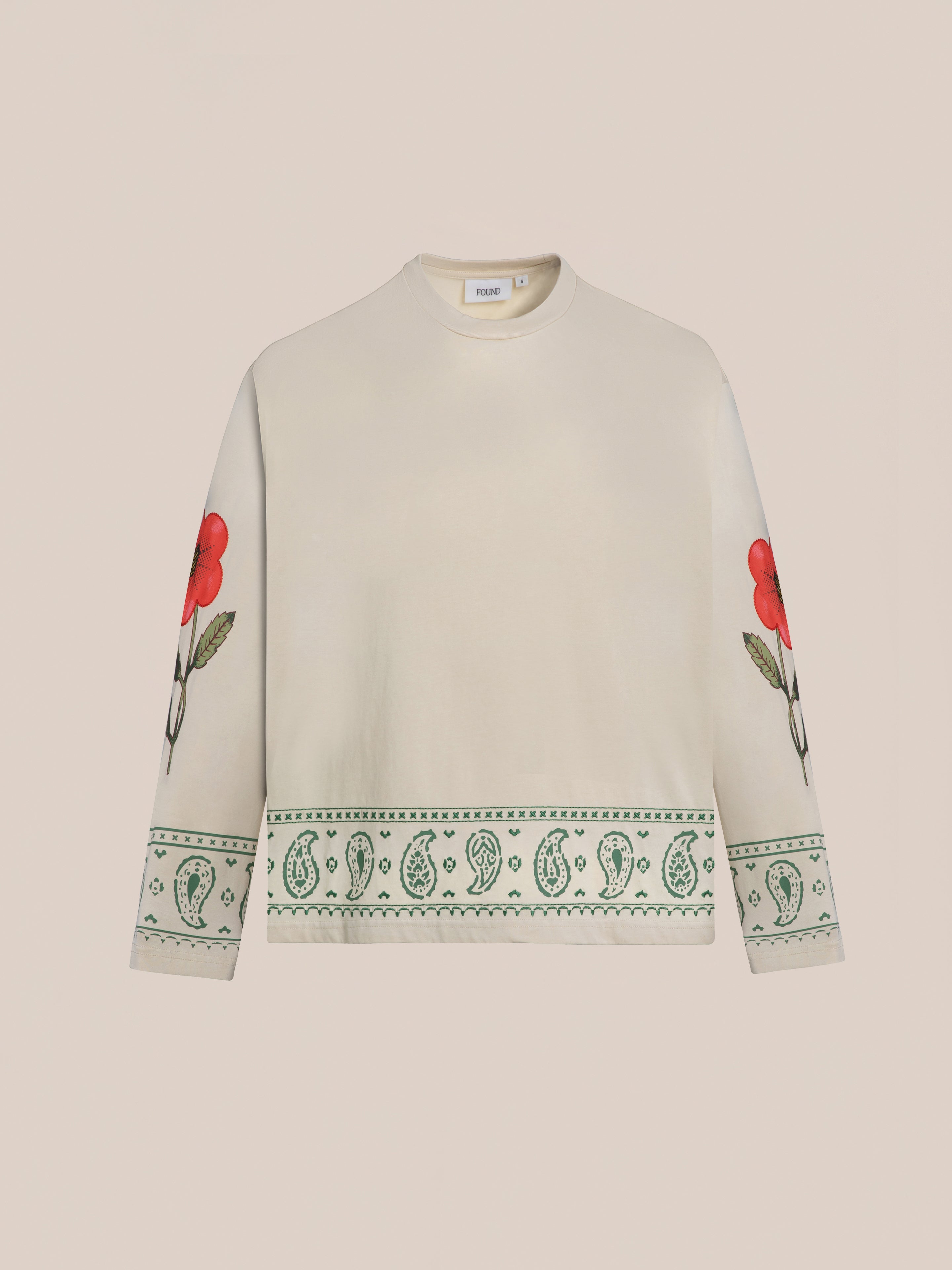 The FOUND Garden Bloom Embroidered LS Tee offers breathable long-sleeve comfort, bold red embroidered floral sleeve graphics, and a green geometric paisley pattern on the hem and cuffs.