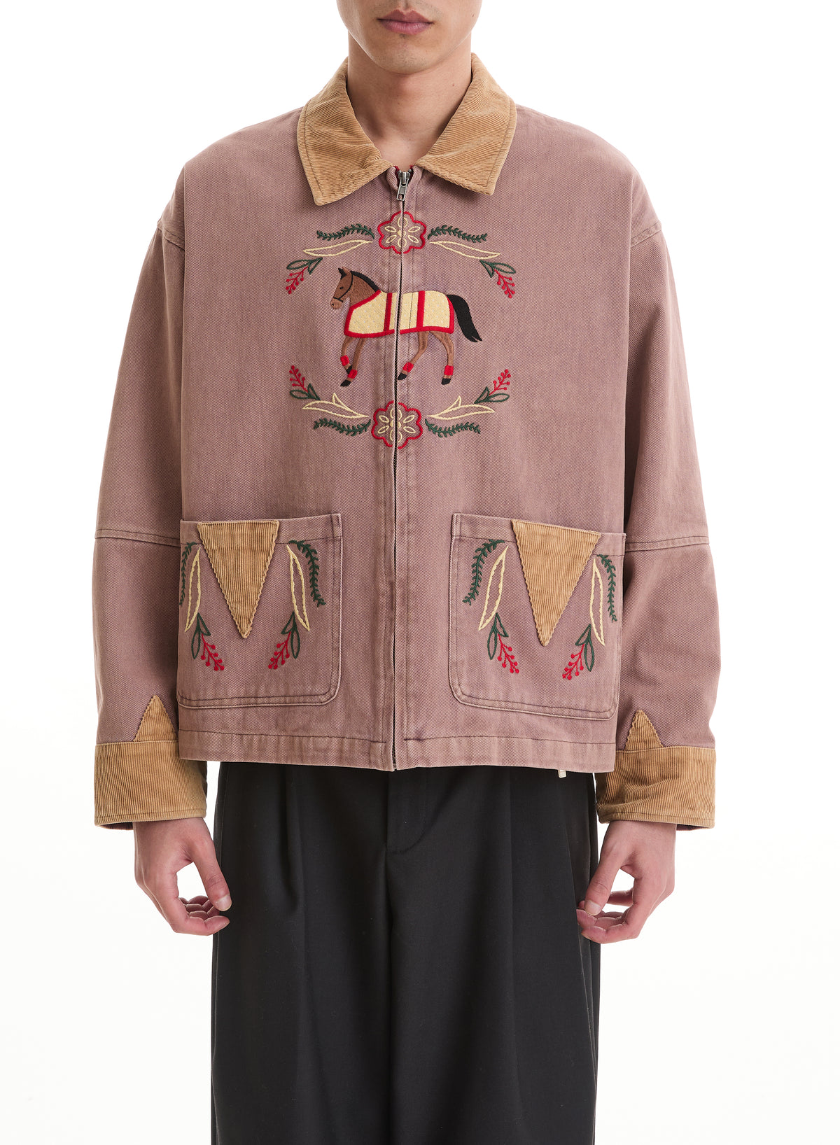 Person wears the FOUND Horse Crest Work Jacket in mauve with tan details and embroidered equestrian motifs, styled with black pants.