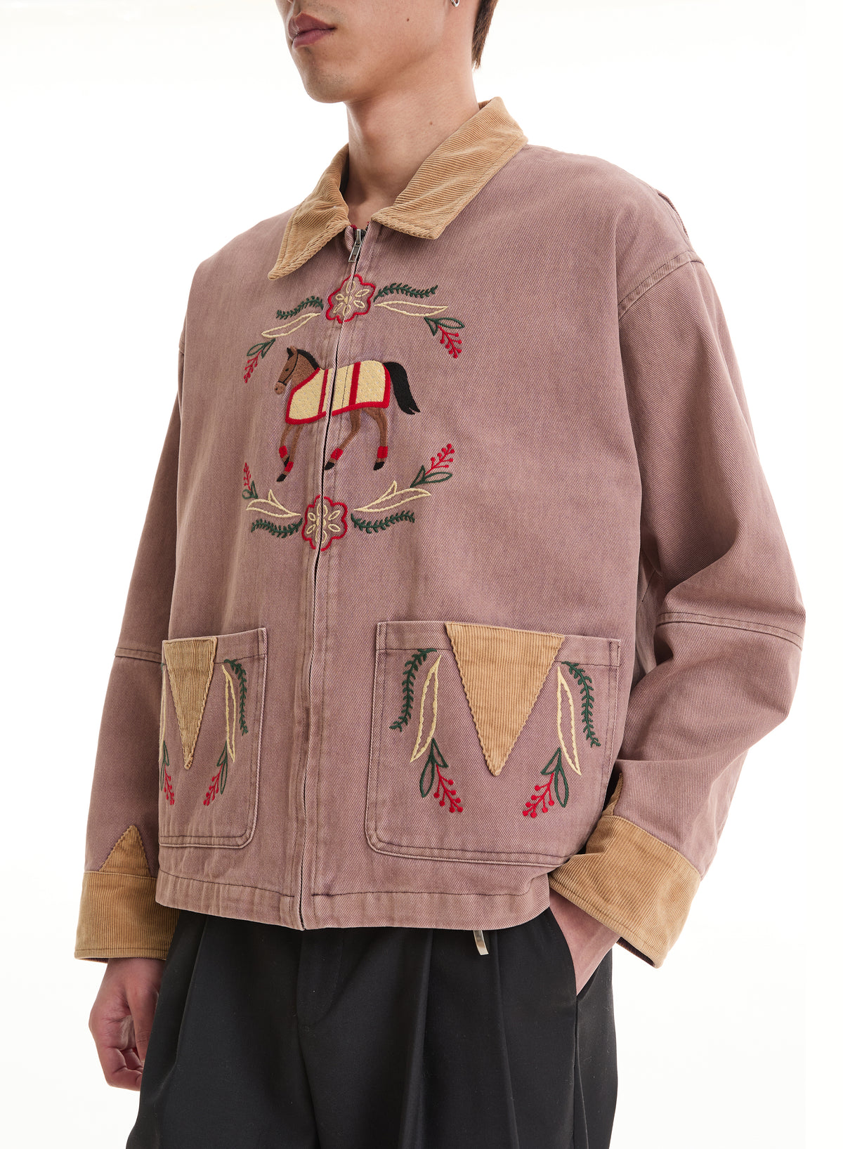 Wearing the FOUND Horse Crest Work Jacket in mauve with embroidered horse and floral designs, tan corduroy details, and black pants.