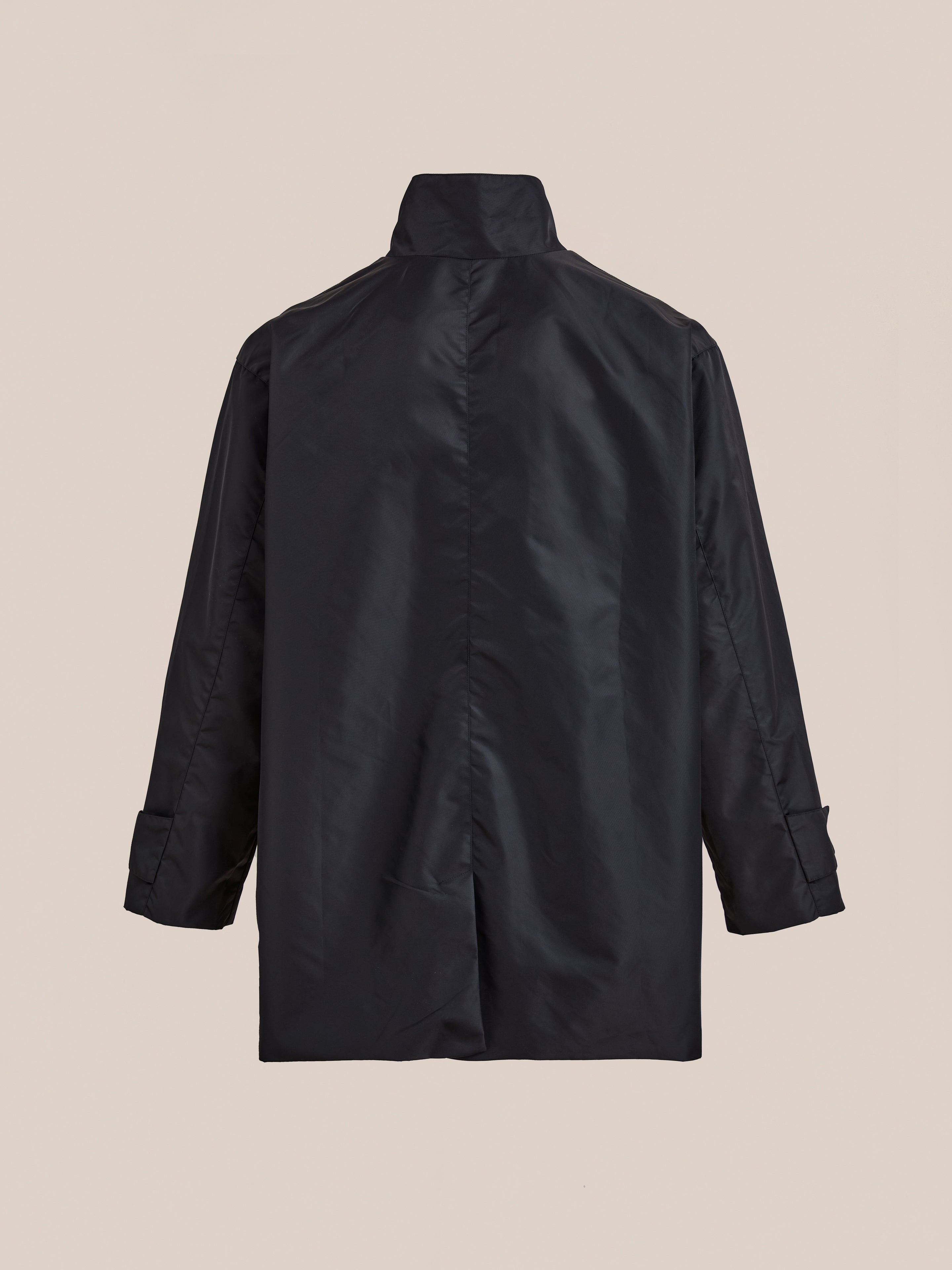 The FOUND Cargo Nylon Jacket, a black unisex utility coat with long sleeves, is displayed from the back against a plain beige background.