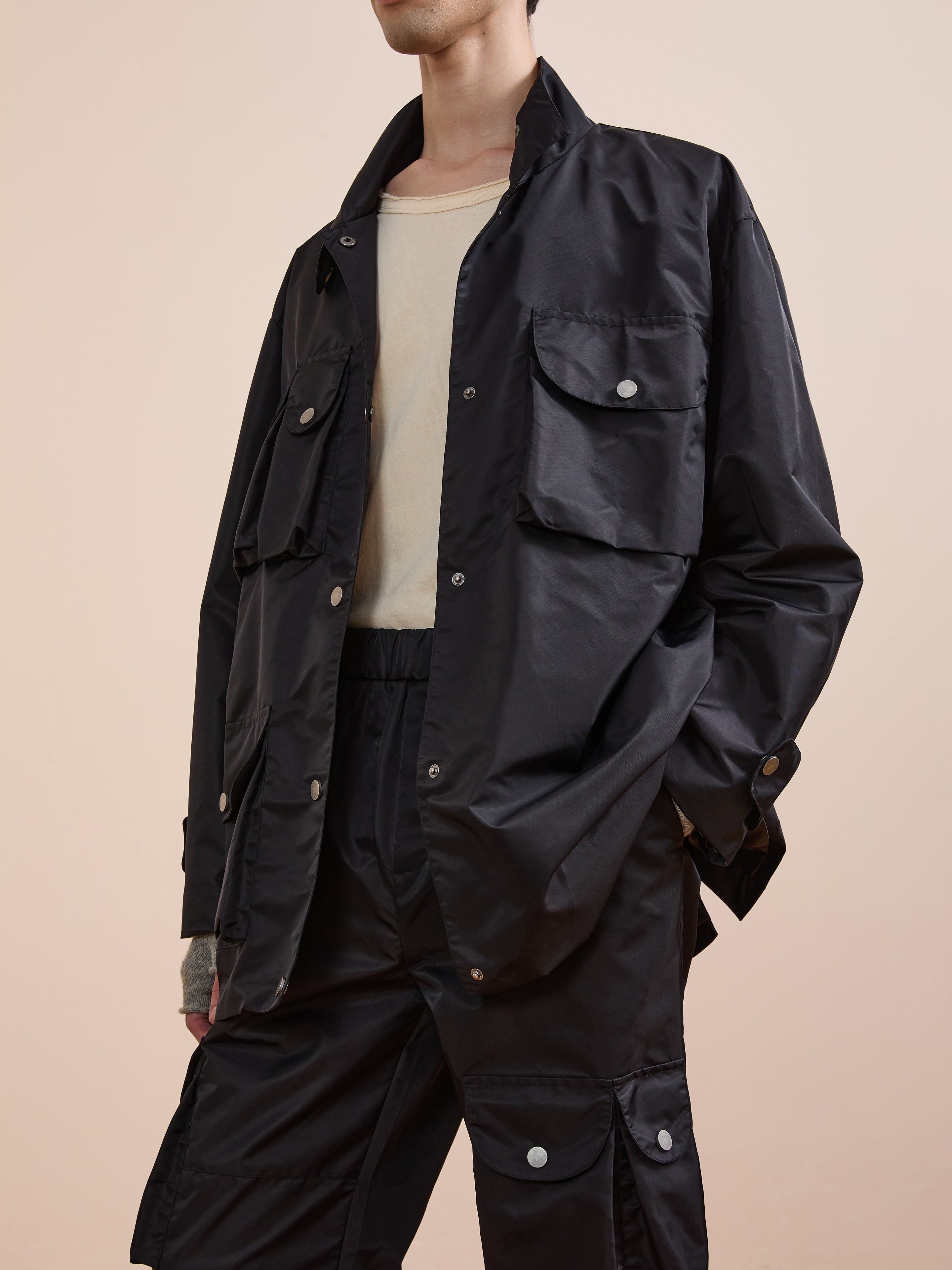 A person wearing the FOUND Cargo Nylon Jacket and matching cargo pants over a beige shirt stands against a plain background.