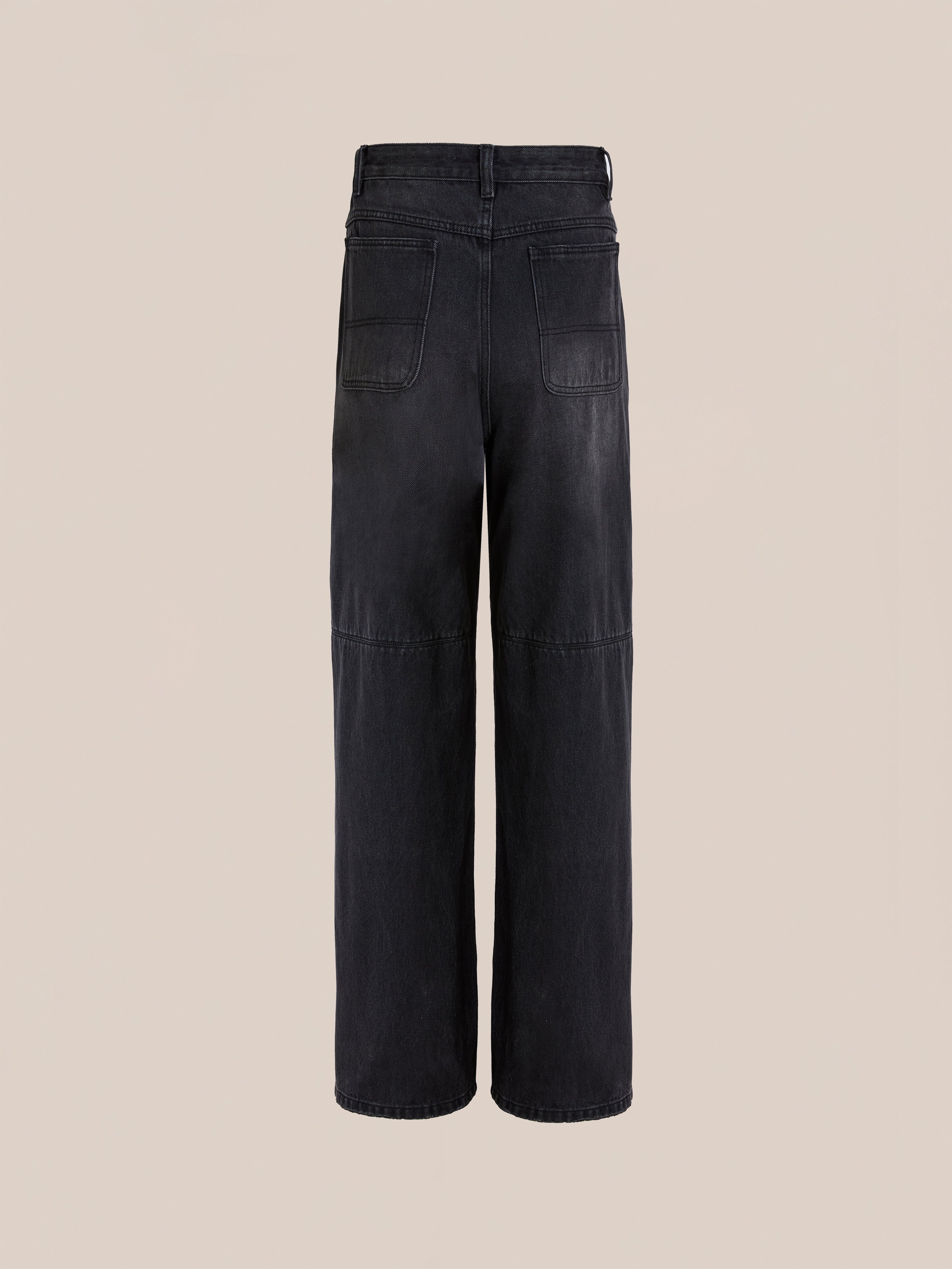 The FOUND Painter Repaired Jeans are black, high-waisted, and wide-leg with two large back pockets and seam details, shown from the back against a plain beige background.
