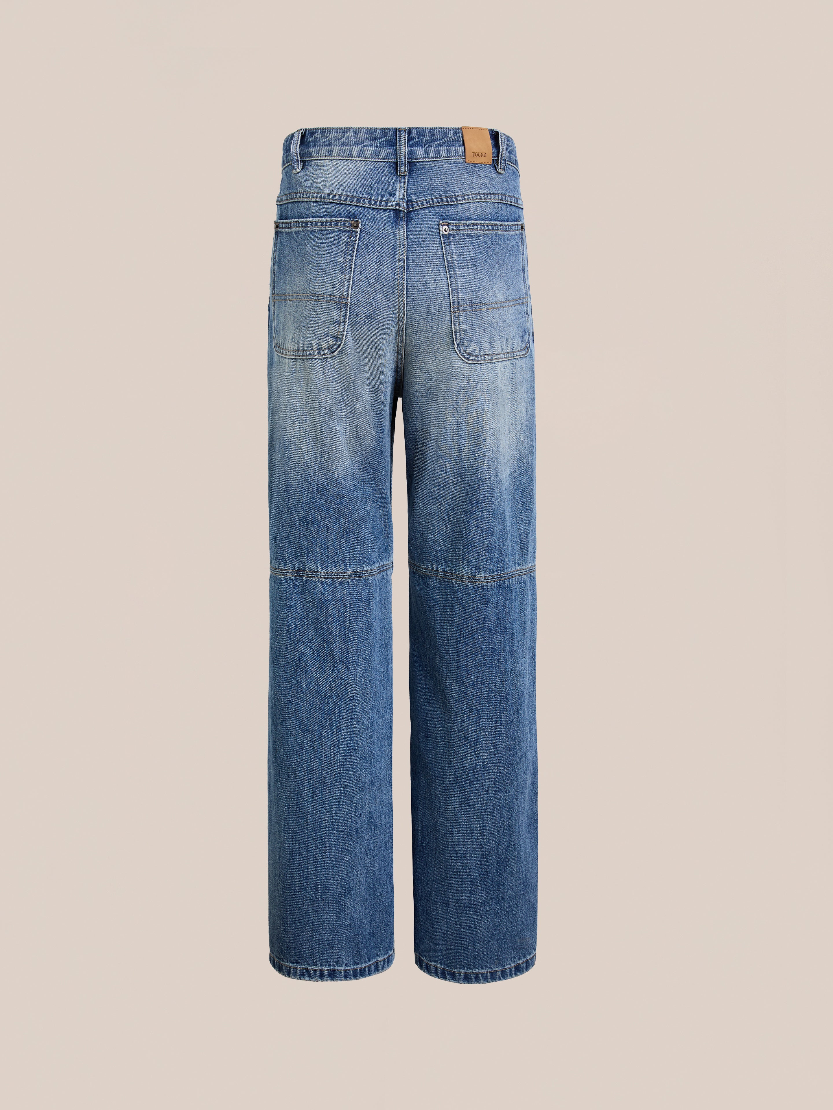 The FOUND Painter Repaired Jeans are blue straight-leg vintage denim with a faded effect, visible back pockets, and a tan leather patch on the waistband, displayed against a neutral background.