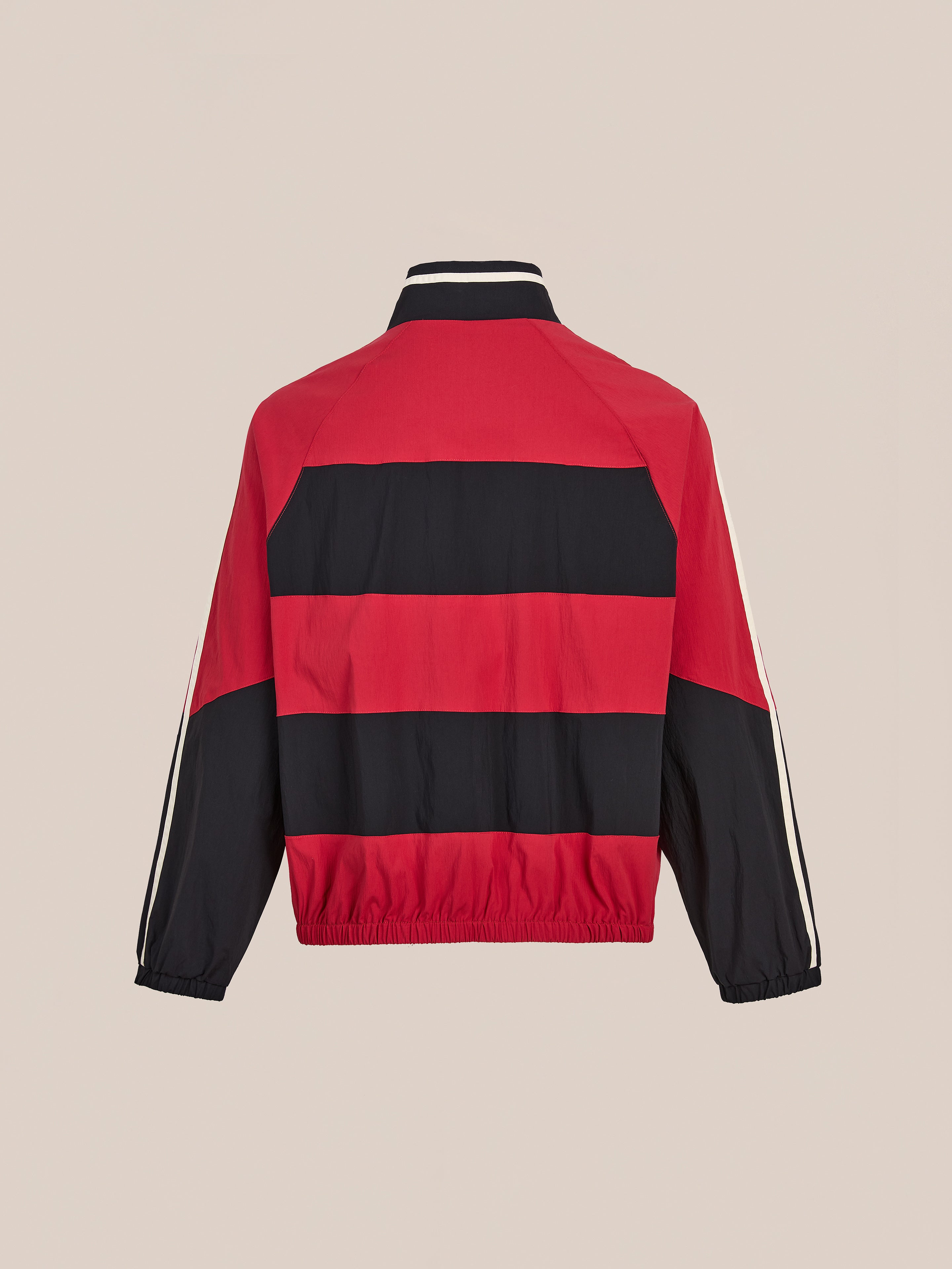 The FOUND Racing Striped Windbreaker is a vintage-inspired red and black jacket with long sleeves, elastic cuffs, and a stand-up collar, shown from the back against a plain background.