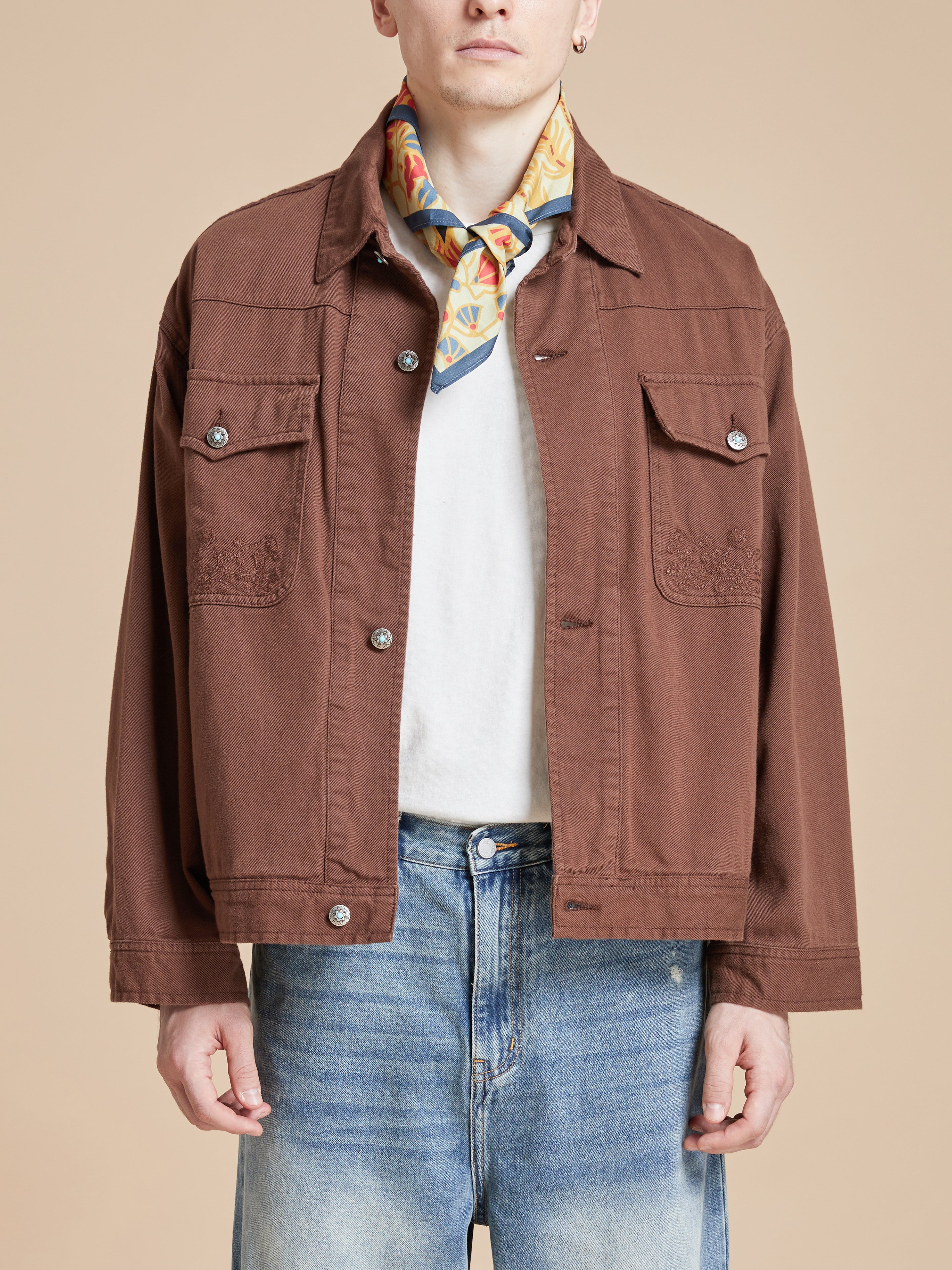 A man wearing Rainforest Bandana artwork on a brown jacket.