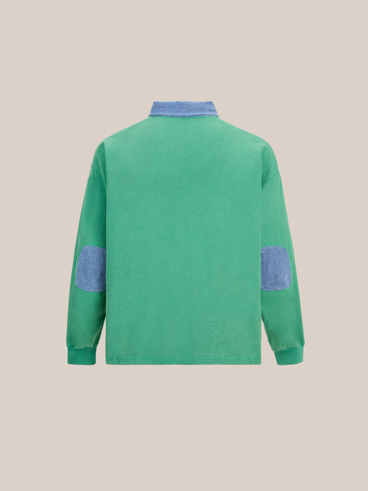 The FOUND Rugby Polo Shirt features a classic collegiate sport-inspired design, showcasing a green midweight cotton fabric with long sleeves, accented by a blue collar and blue elbow patches. It is displayed against a plain beige background.