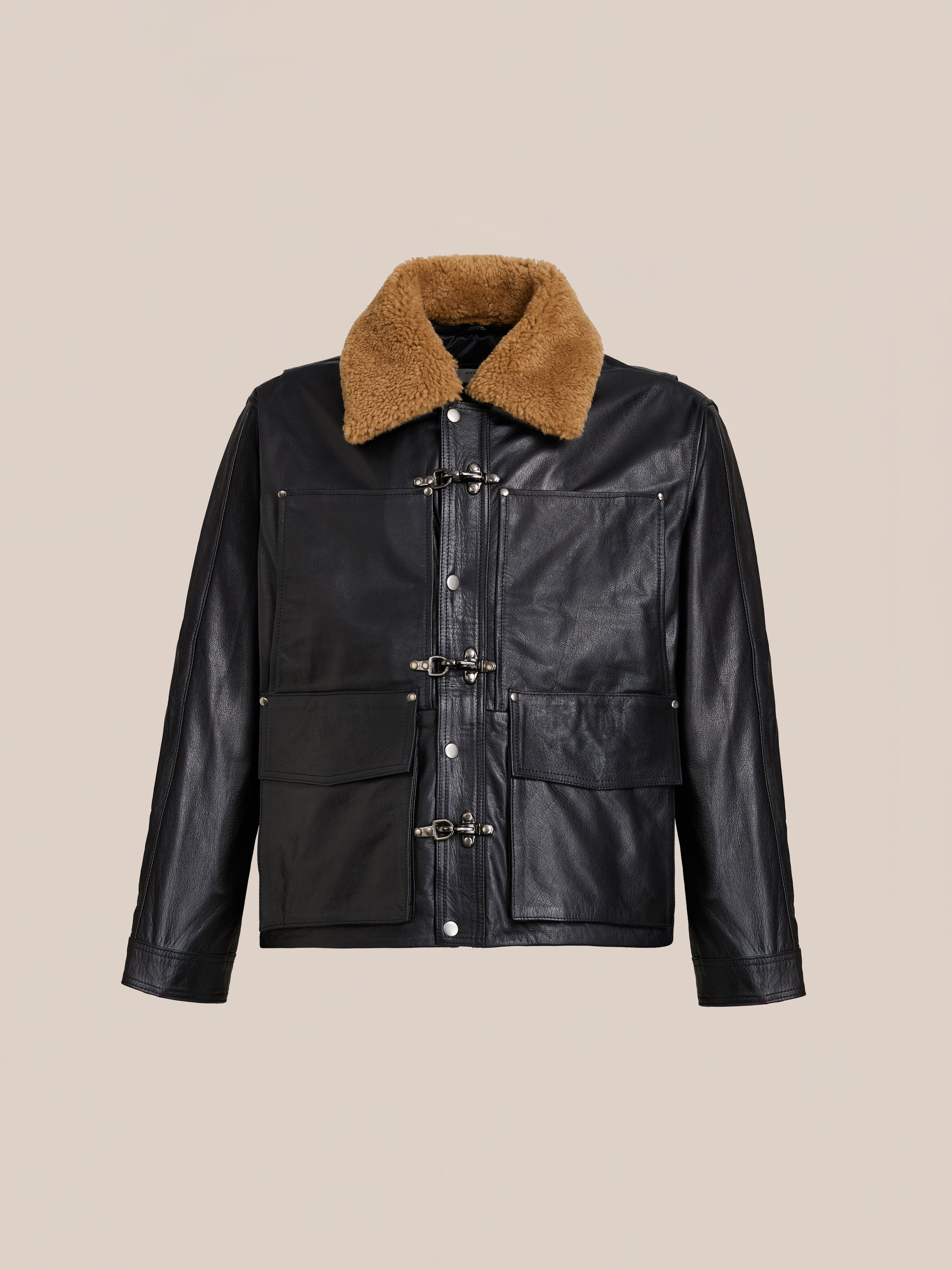 The FOUND Sherpa Collar Leather Utility Jacket, crafted from genuine leather with a brown shearling collar, large front pockets, and metal clasp closures, is displayed on a plain beige background.