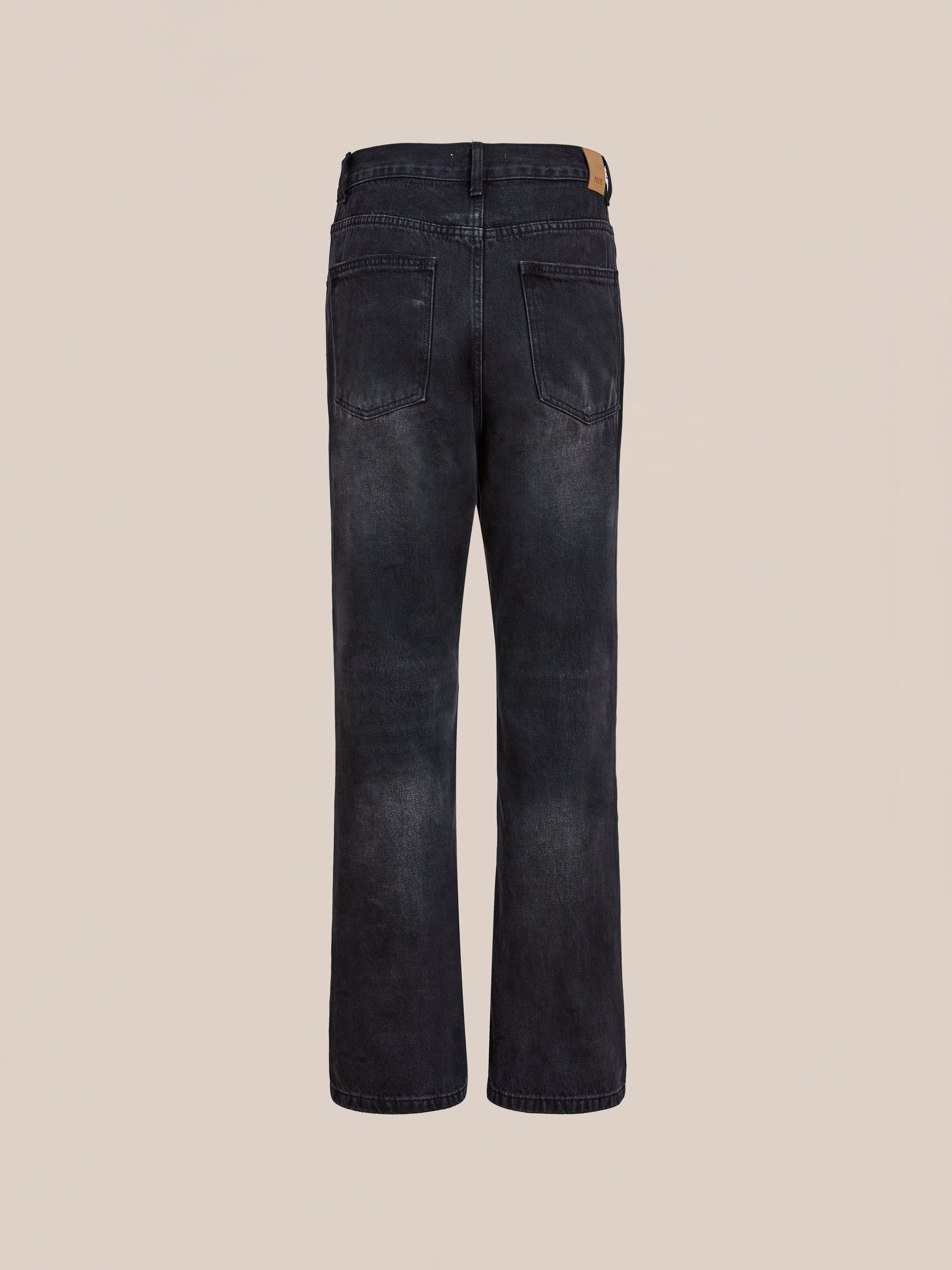 Back view of Found Straight Leg Jeans in black cotton denim, unisex design with two rear pockets and a tan leather patch on the waistband, shown against a plain light background.