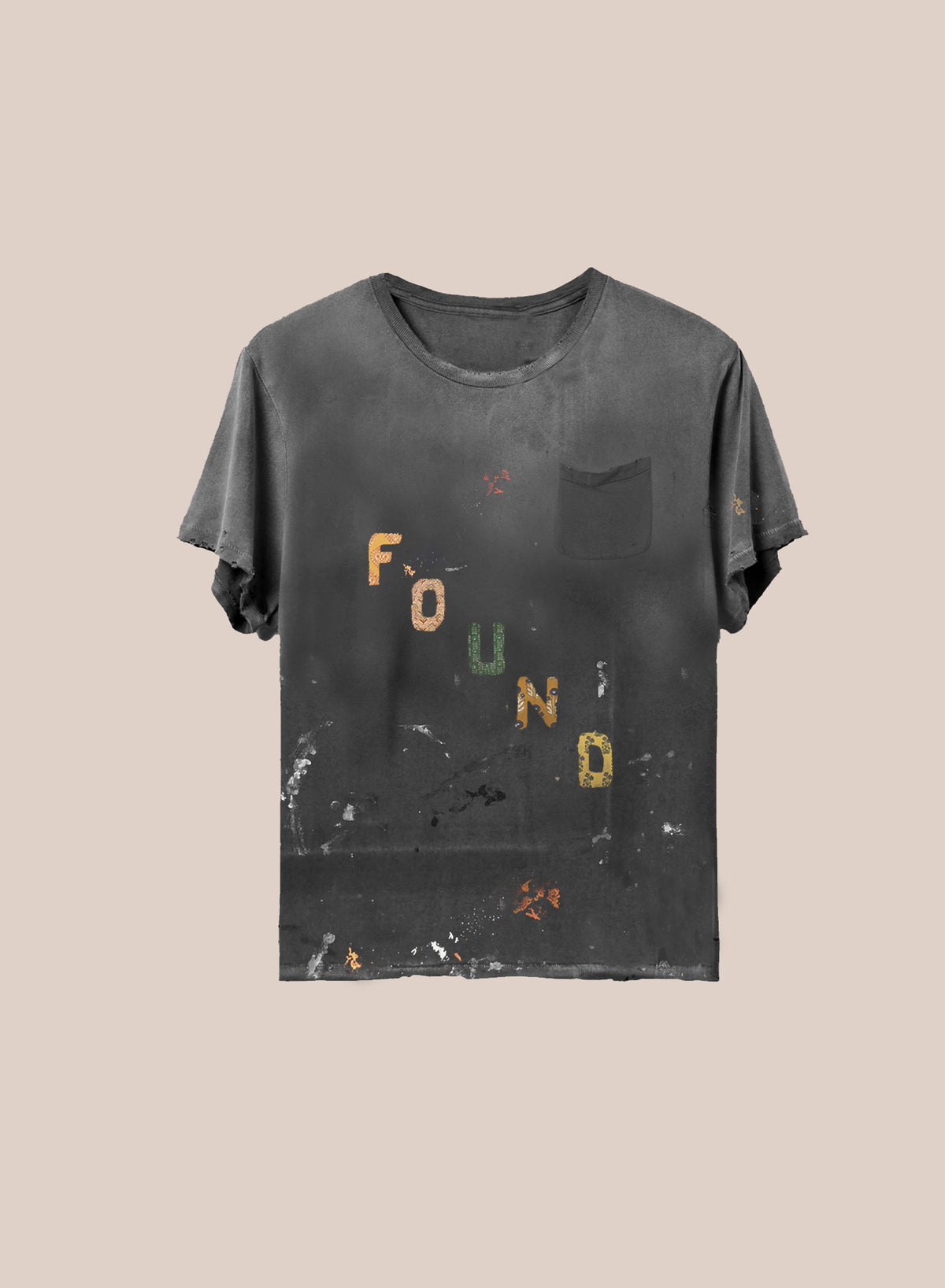 The Tapestry Logo Paint Tee by FOUND is a dark gray, relaxed unisex tee with rolled sleeves, a chest pocket, and colorful “FOUND” lettering.