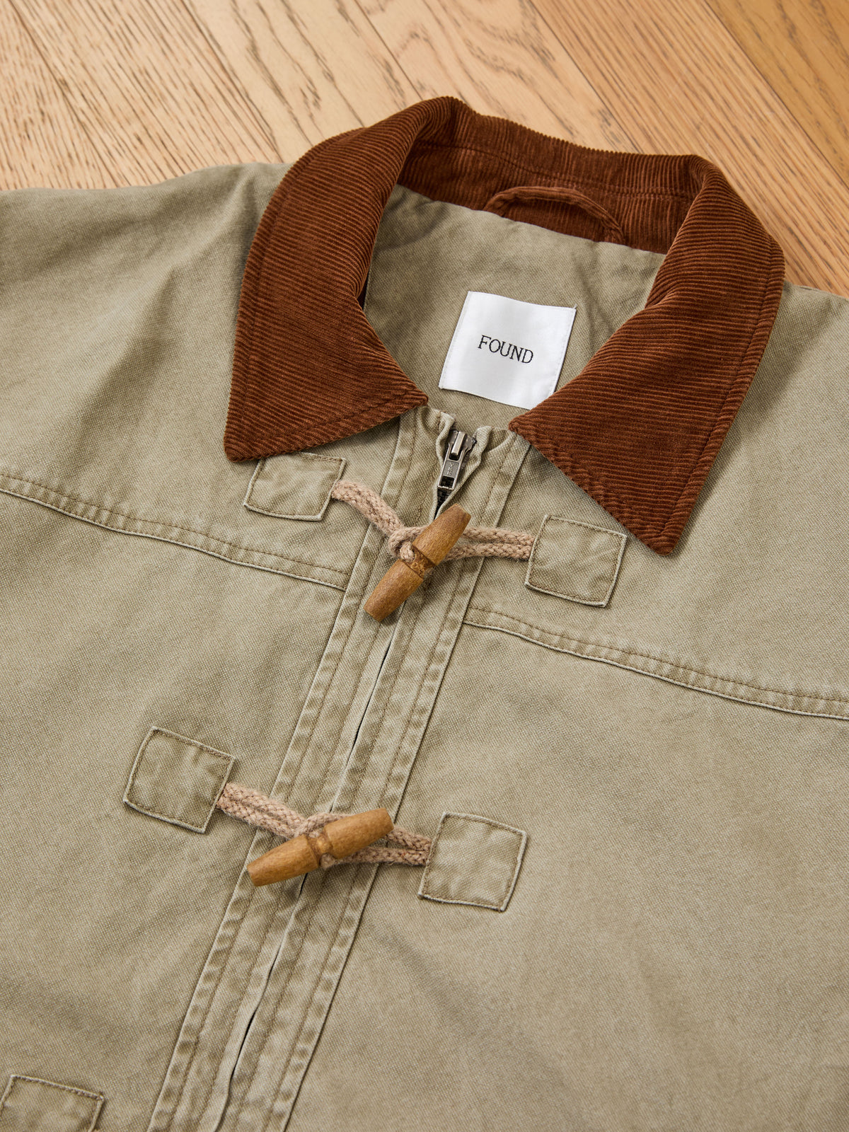 FOUND Toggle Work Jacket with brown corduroy collar and vintage utility details, shown on a light wood floor.