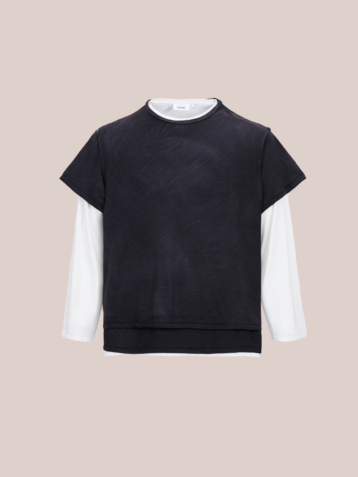 The FOUND Triple Layer Tee, a black-over-white unisex relaxed fit t-shirt, is shown on a plain beige background.