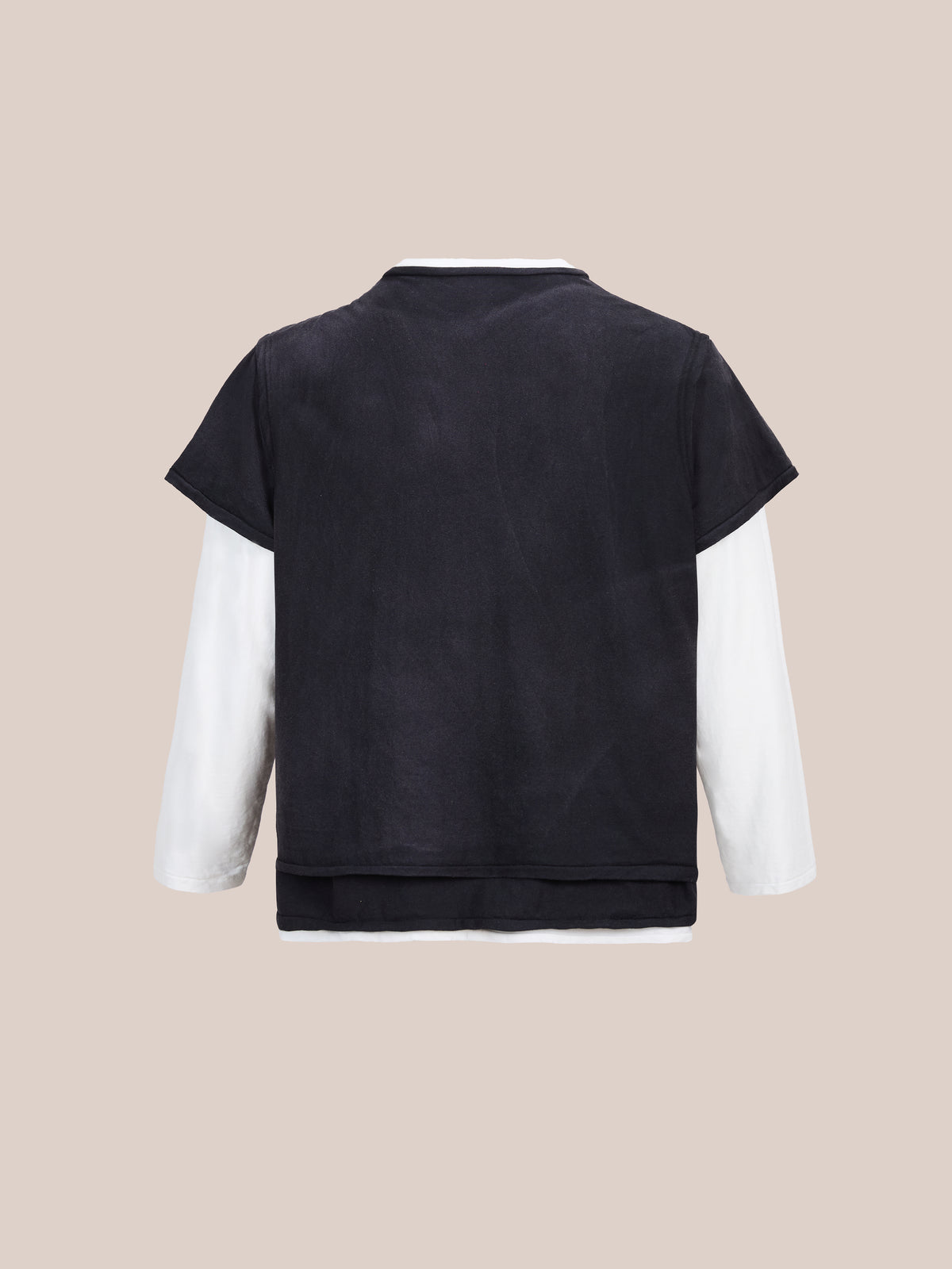 The FOUND Triple Layer Tee is a unisex relaxed fit with black short sleeves over white long sleeves, shown from the back on a beige background.