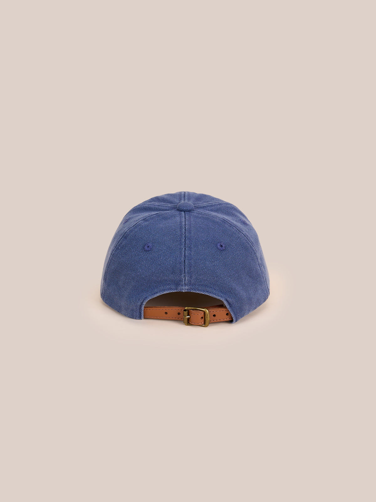 The Vintage Club Cap by Found in blue corduroy is shown from the back with an adjustable leather strap and brass buckle on a plain light beige background.