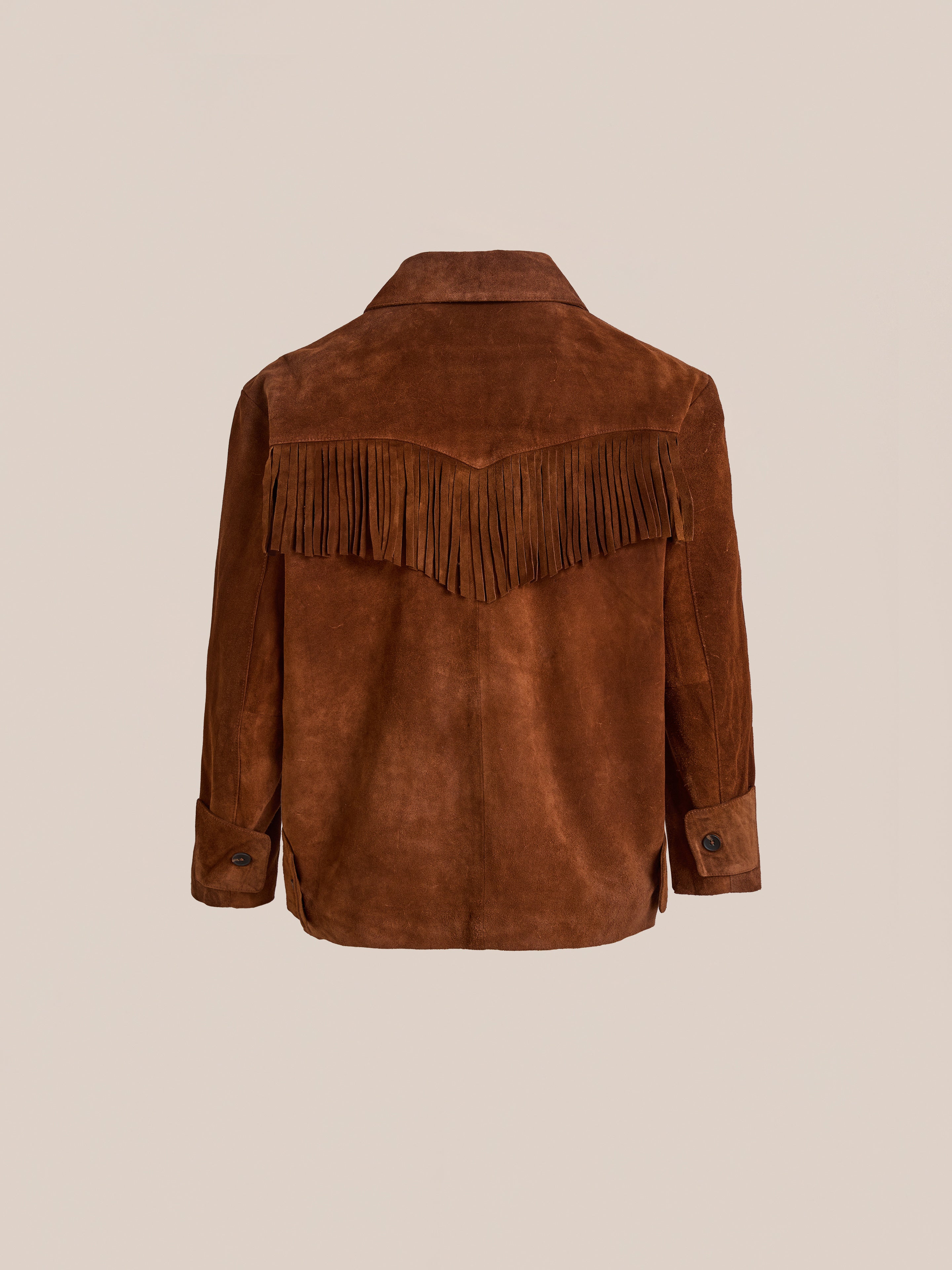The FOUND Hand Embroidered Suede Fringe Jacket is a brown unisex outerwear piece with long sleeves, fringe across the back yoke, and classic Western style, displayed against a plain beige background.