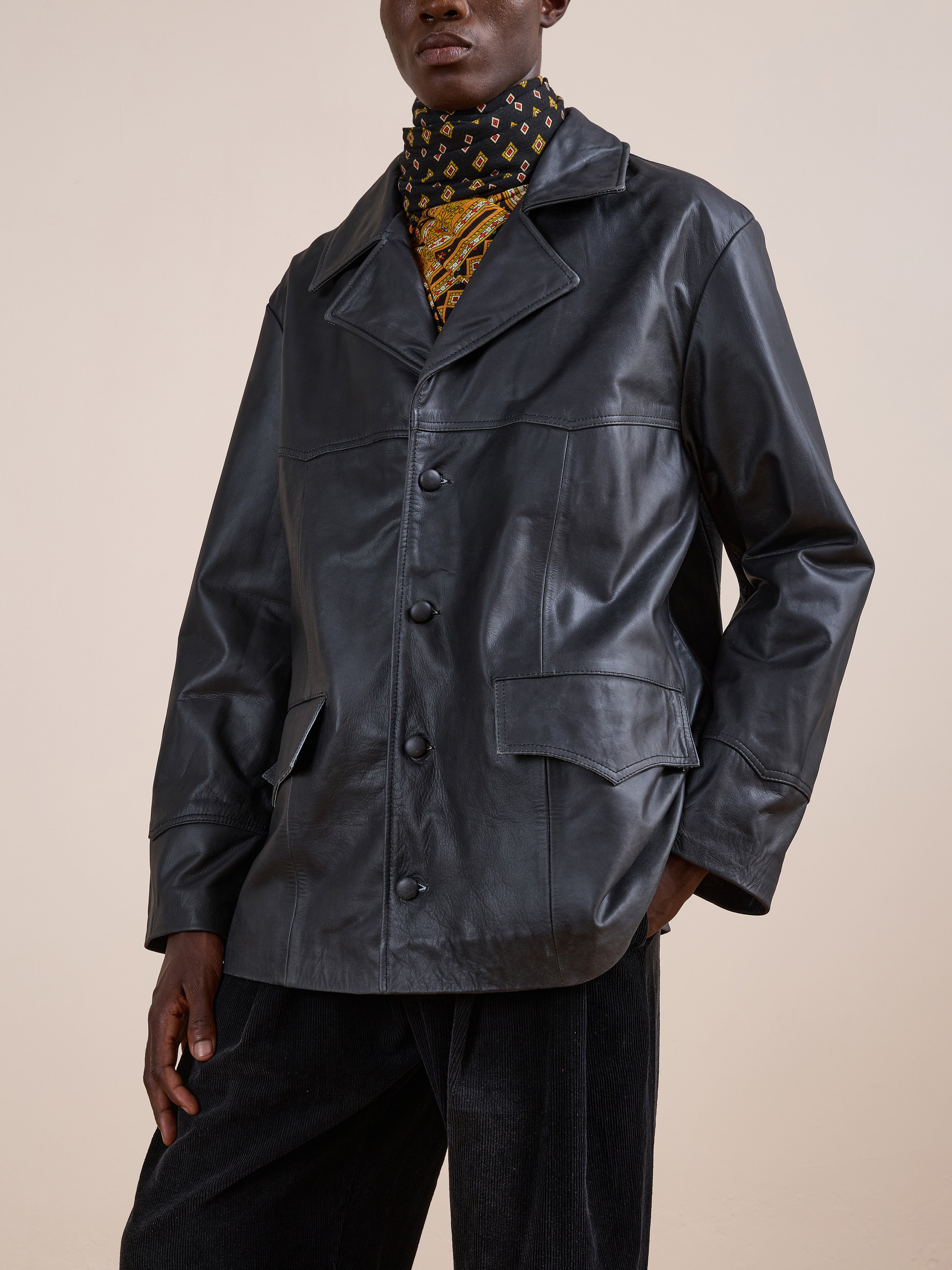 A person models the FOUND Western Oversized Leather Blazer, featuring large lapels and front pockets, layered over a patterned turtleneck against a plain backdrop.