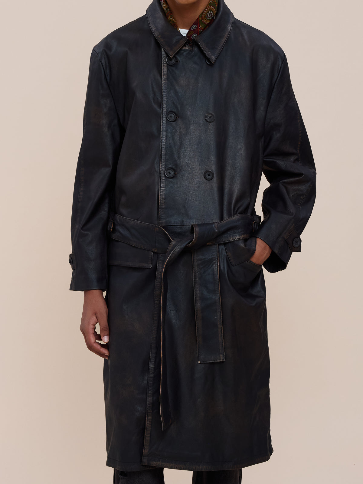 A person wears the FOUND Belted Leather Trench Coat, double-breasted with a belt, hand in pocket, posed against a plain background.