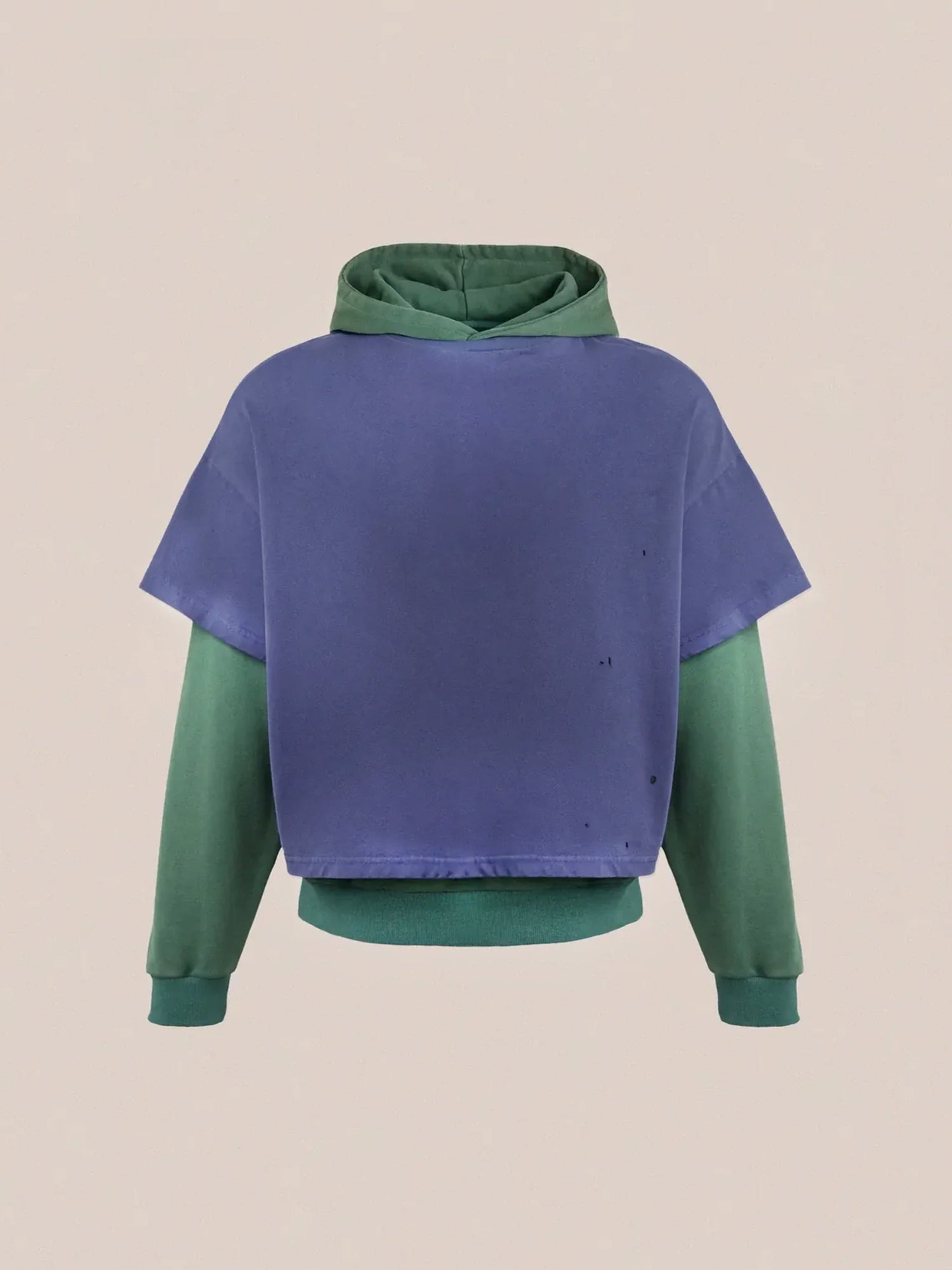 Introducing the "Double Layer Hoodie" by Found: a stylish piece crafted from French terry cotton, showcasing a green hood and sleeves paired with a purple short-sleeve overlay for a vintage look against its plain backdrop.