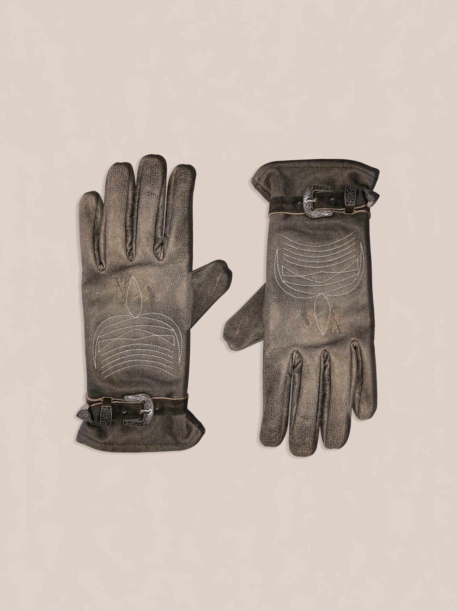 The Distressed Leather Western Gloves by FOUND, featuring decorative stitching and buckle details in brown leather, are displayed on a light background.