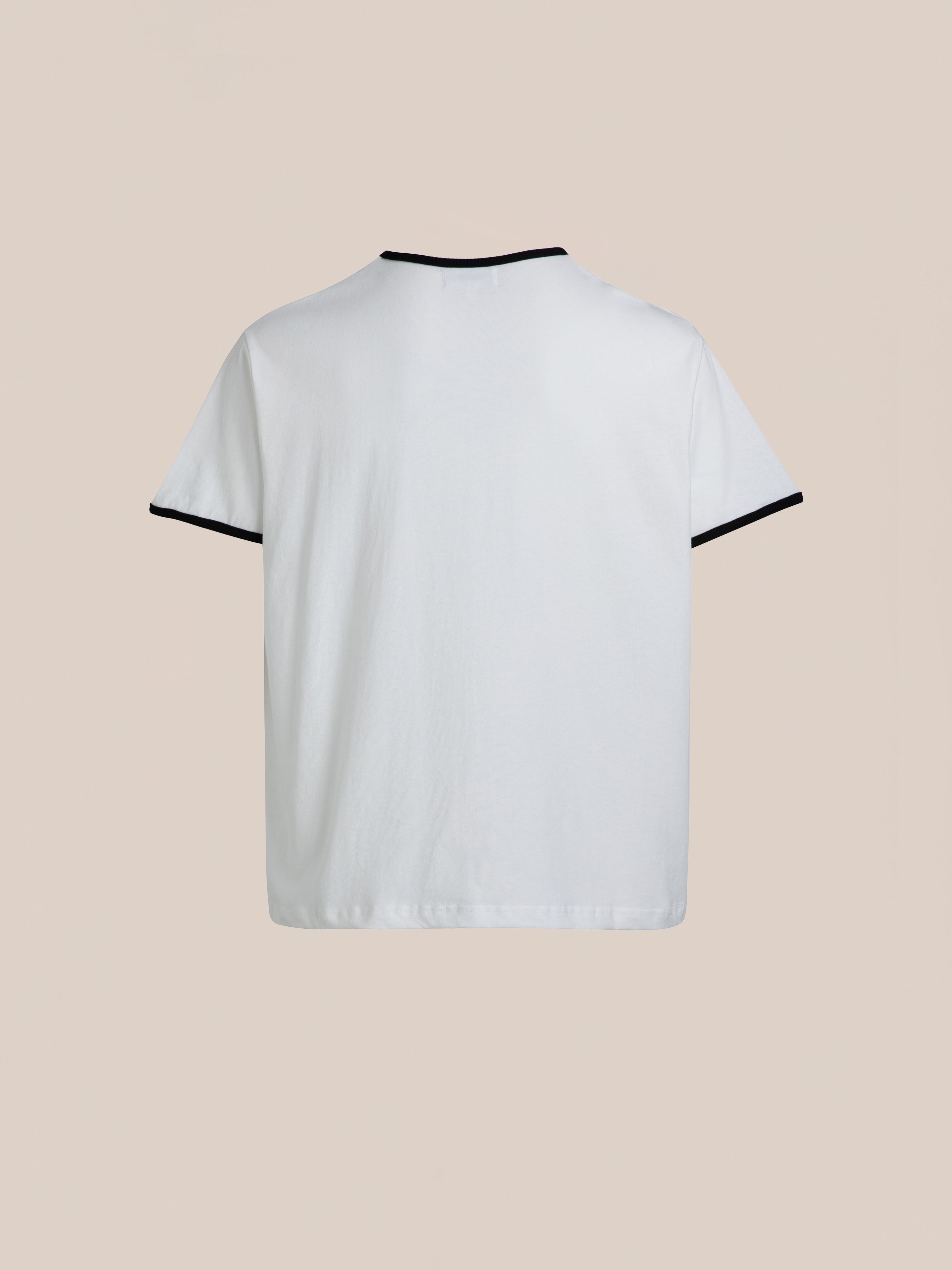 The Horse Crest Ringer Tee by FOUND, a plain white short-sleeved T-shirt with black trim on the collar and sleeves, is pictured against a beige background.