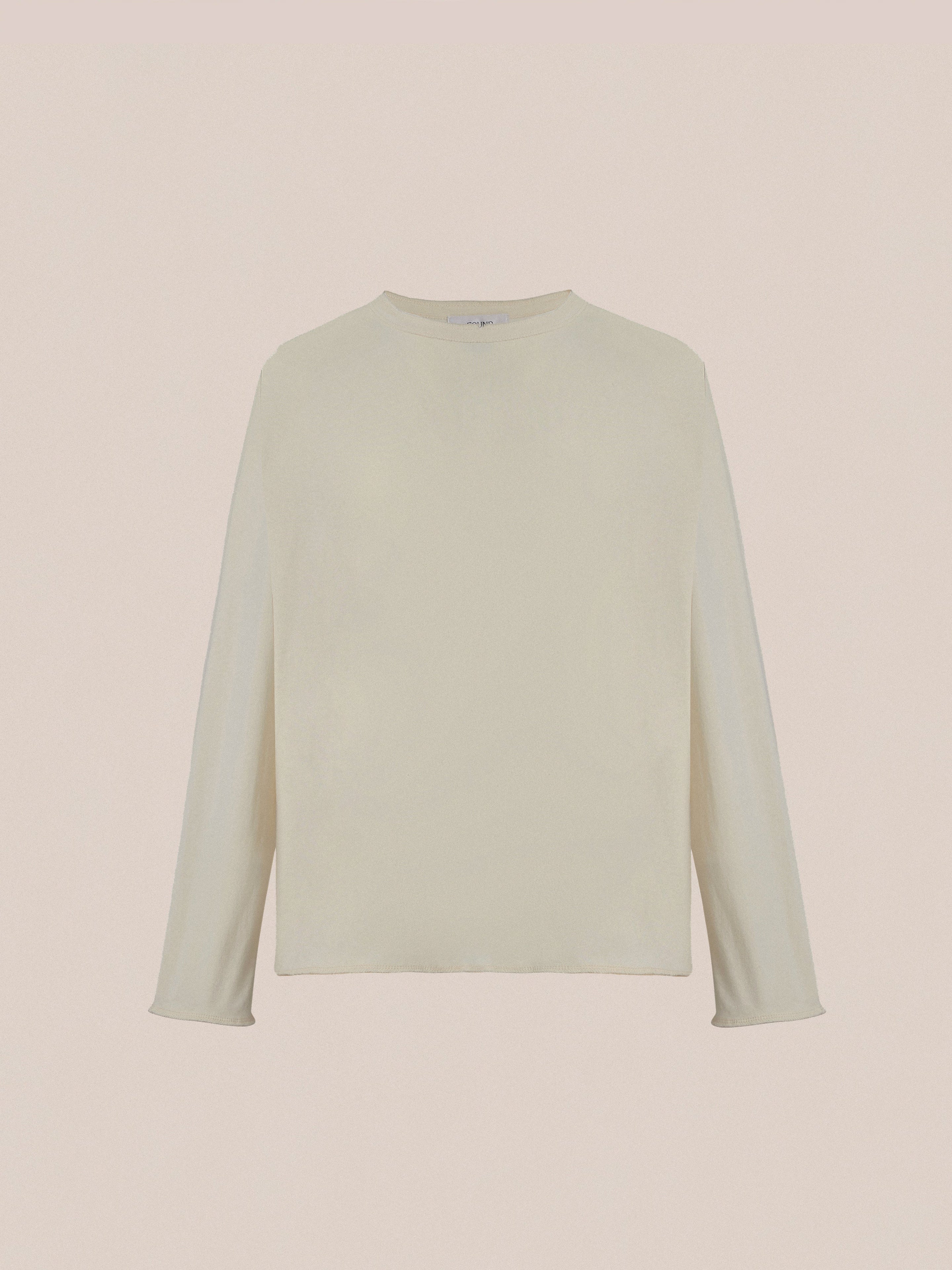 FOUND Reversed LS Tee: light beige unisex long sleeve shirt with a classic crew neckline and subtle distressed detail, shown against a plain beige background.