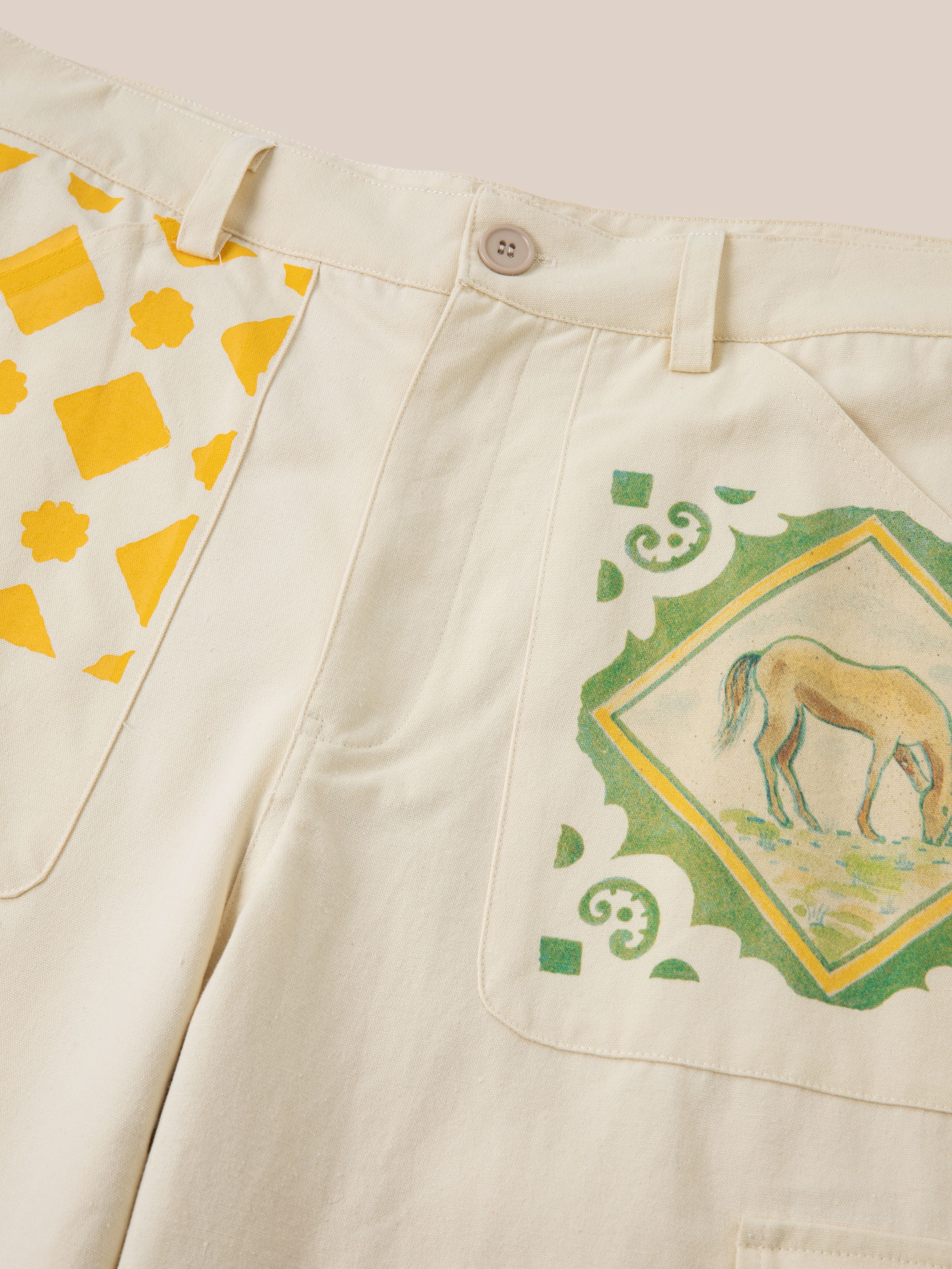 FOUND's unisex Mosaic Pants blend beige fabric with yellow geometric and Indo-Aryan patterns, highlighted by a unique horse illustration on the pockets.