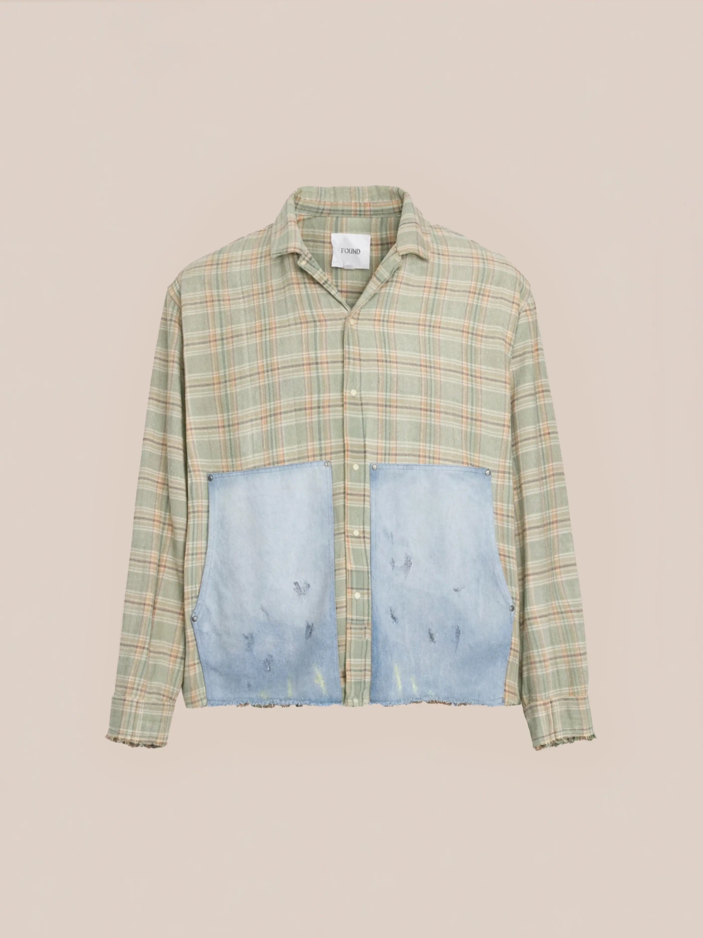 The FOUND Plaid Denim Shirt is a unisex relaxed fit green plaid workwear shirt with long sleeves and large light blue denim patch pockets on the front, shown against a plain background.