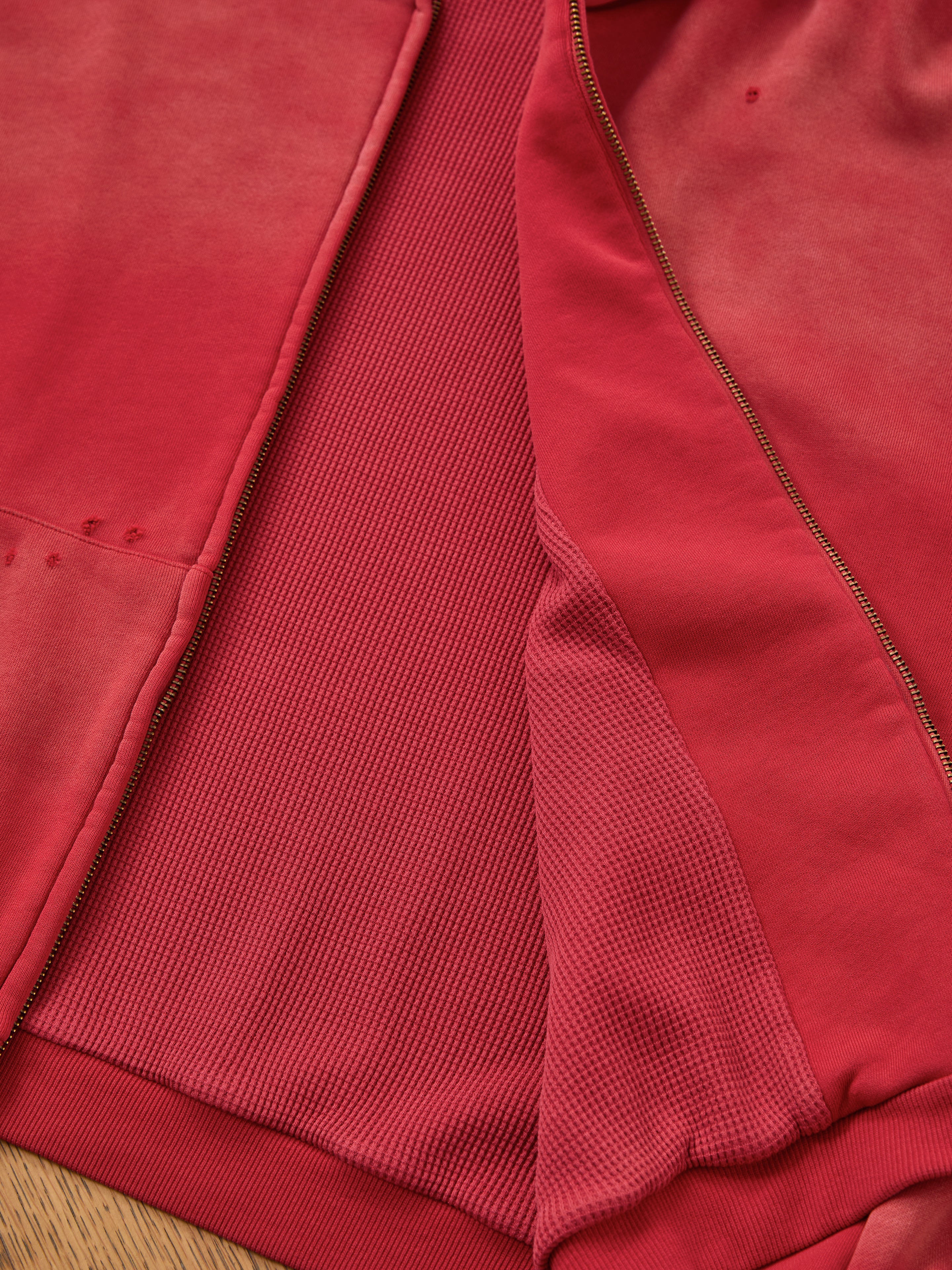 Close-up of the FOUND Distressed Thermal Lined Zip Up Hoodie features ribbed thermal lining, smooth outer fabric, and part of the zipper.