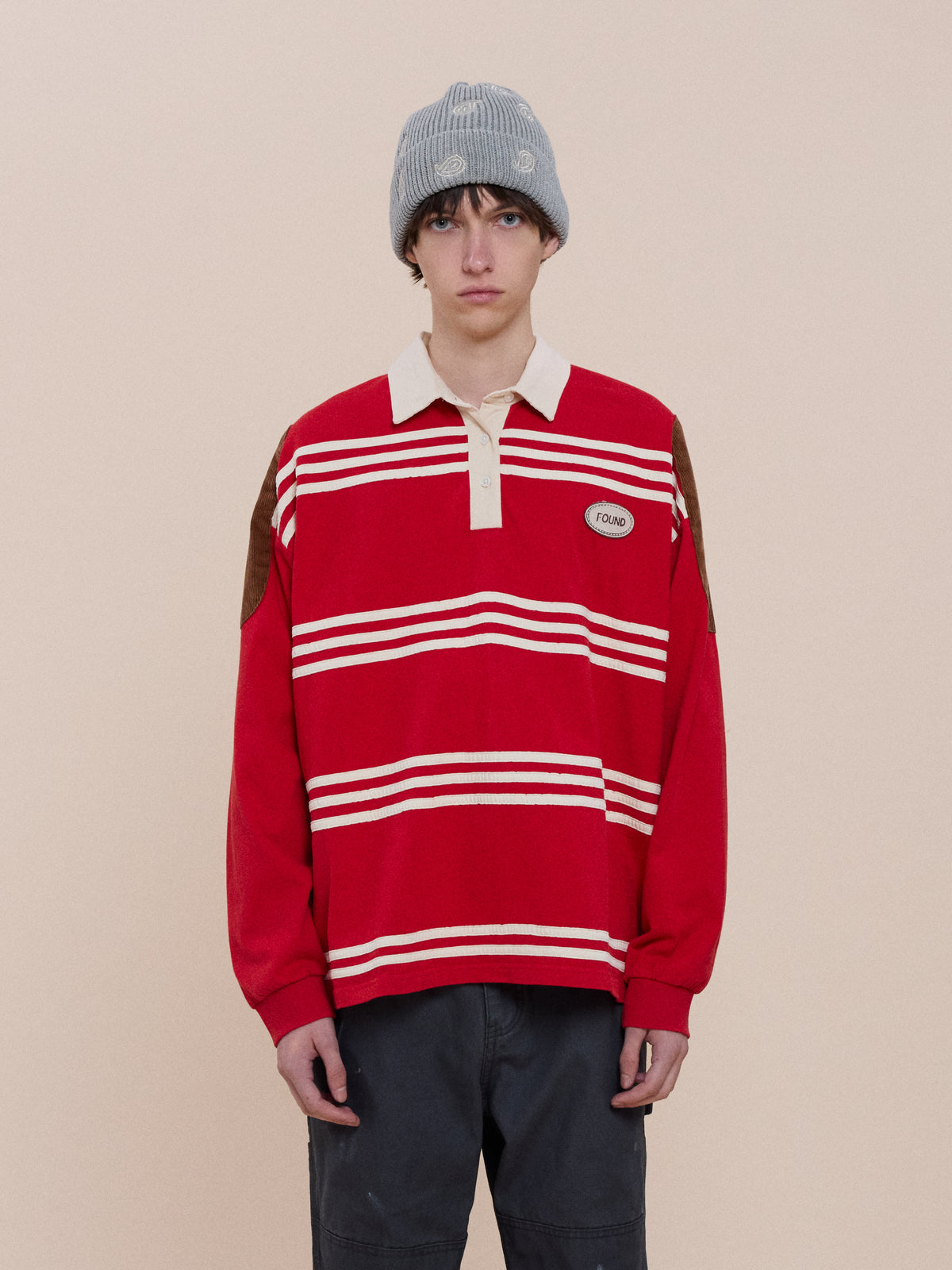 A person wearing the FOUND Striped Corduroy Rugby Polo stands against a beige background, looking directly at the camera.