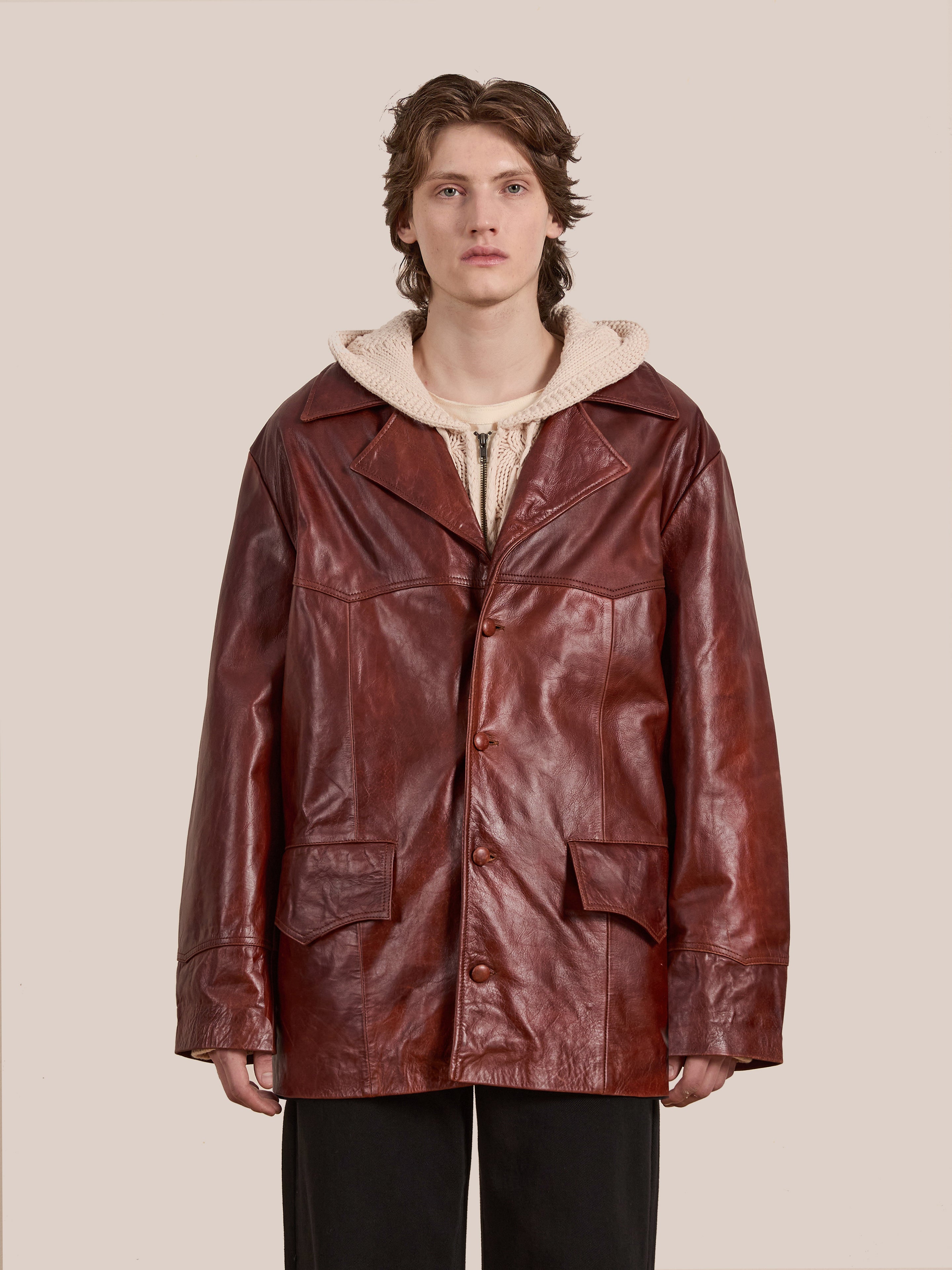 A person models the FOUND Claret Western Oversized Leather Blazer over a beige hoodie against a plain background.